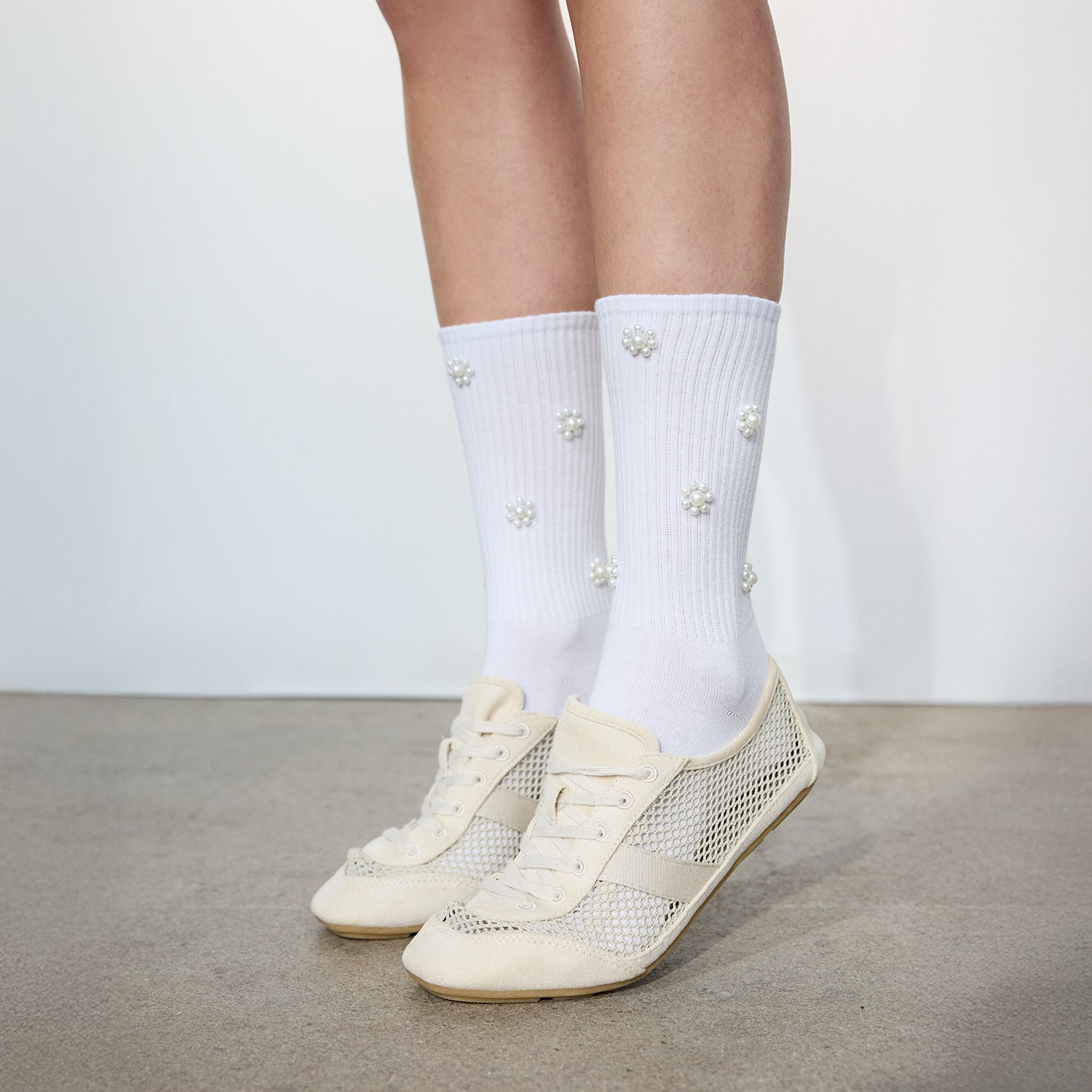 Vogue naisten valkoiset Chloe sukat, joissa helmiyksityiskohtia yhdistettynä vaaleisiin tennareihin.