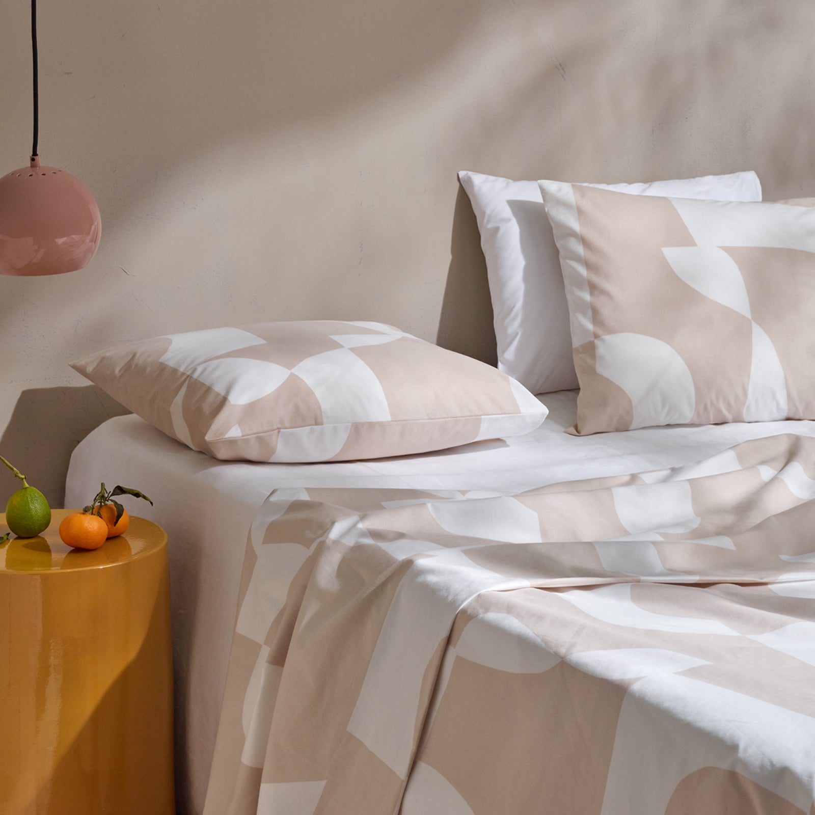Nanson beige-valkoinen Kallio-pussilakanasetti harmonisella graafisella kuviolla pedattuna sänkyyn harmonisen sisustuksen kanssa.