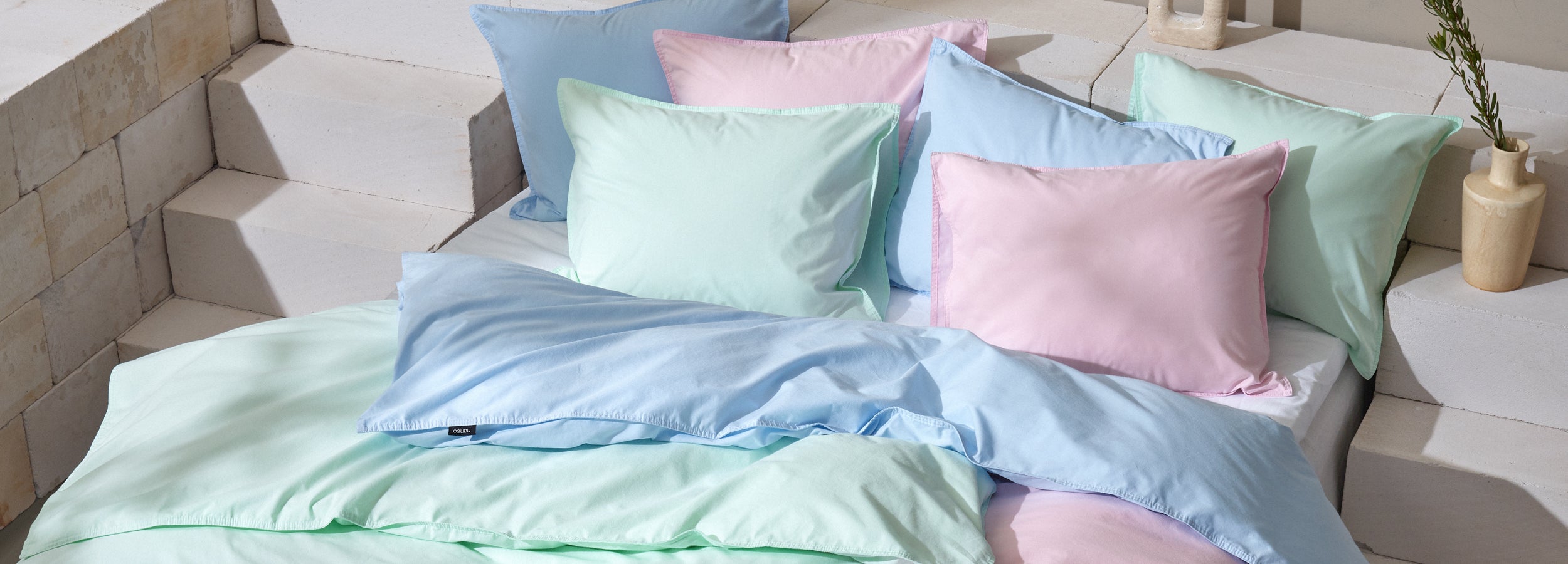 Nanson tunnelmallisessa brändikuvassa pastellinsävyiset Uni -pussilakanasetit pedattuna.