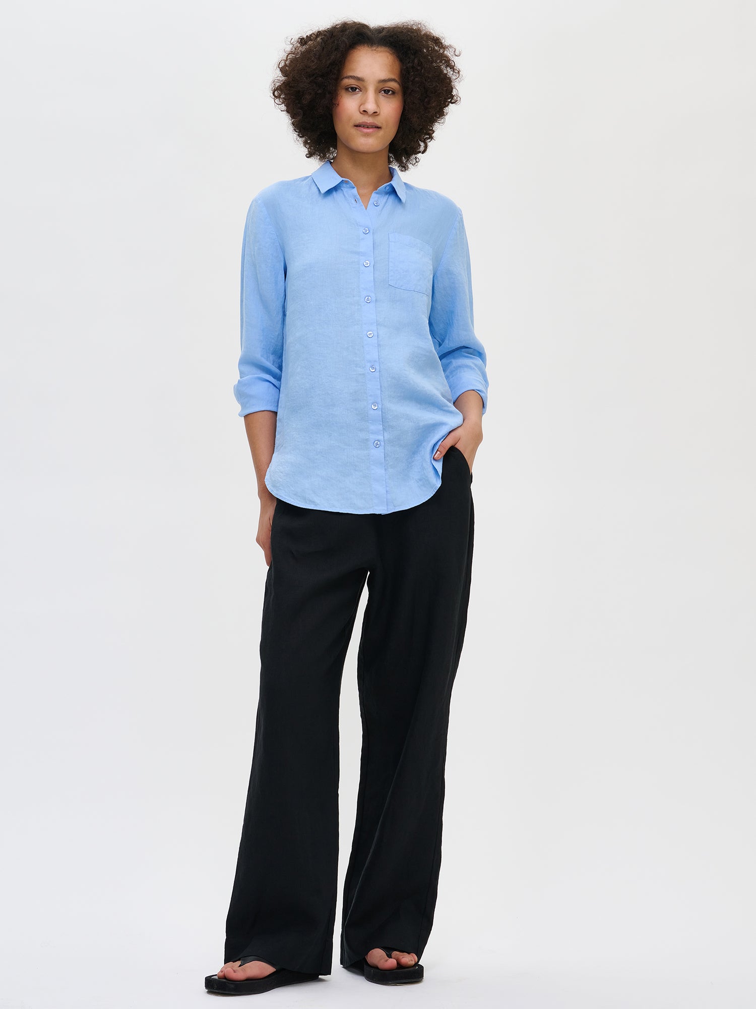 Nanson naisten rento sininen Pellava-paitapusero mallin päällä mustien pellavahousujen kanssa.