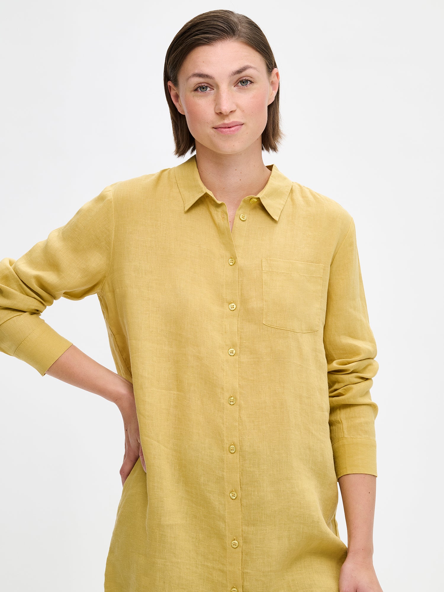 Naisten rento ja pitkä keltainen Pellava-paitapusero mallin päällä läheltä kuvattuna.