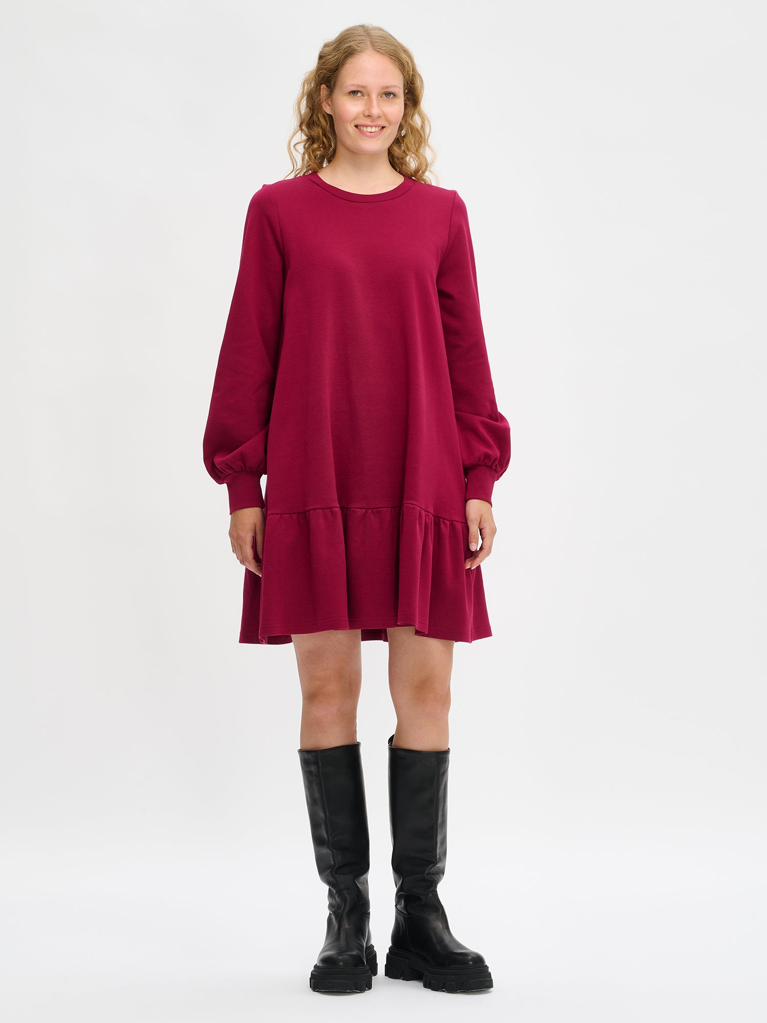 Nanson naisten viininpunainen Leija-mekko mallin yllä kokokuvassa, lyhyt malli polven yläpuolelle, pyöreä pääntie, pitkät pussihihat ja poimutettu helma.