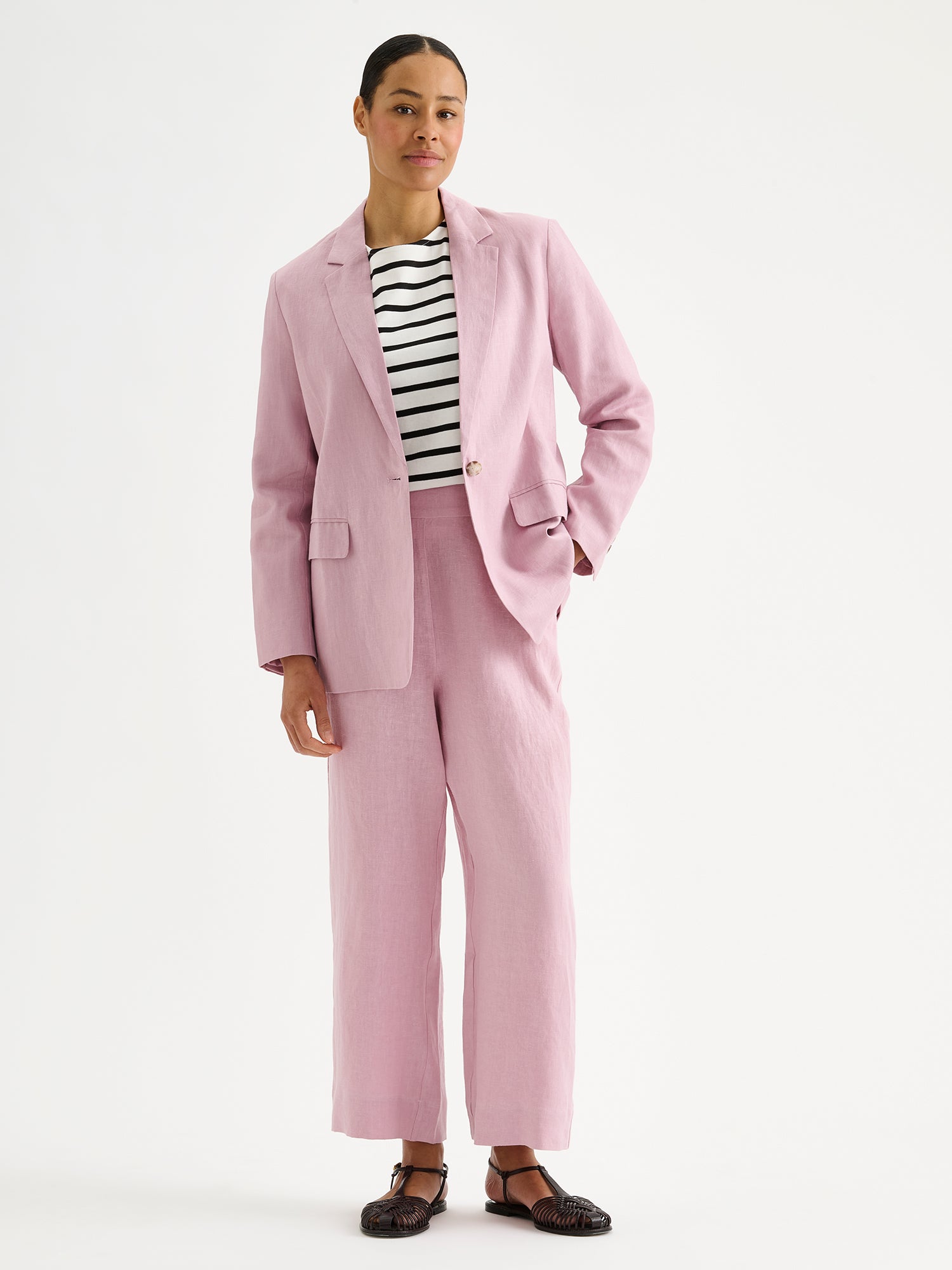 Nanson naisten roosat Saari-pellavahousut vajaamittaisilla lahkeilla mallin päällä roosan Arles -pellavajakun kanssa.