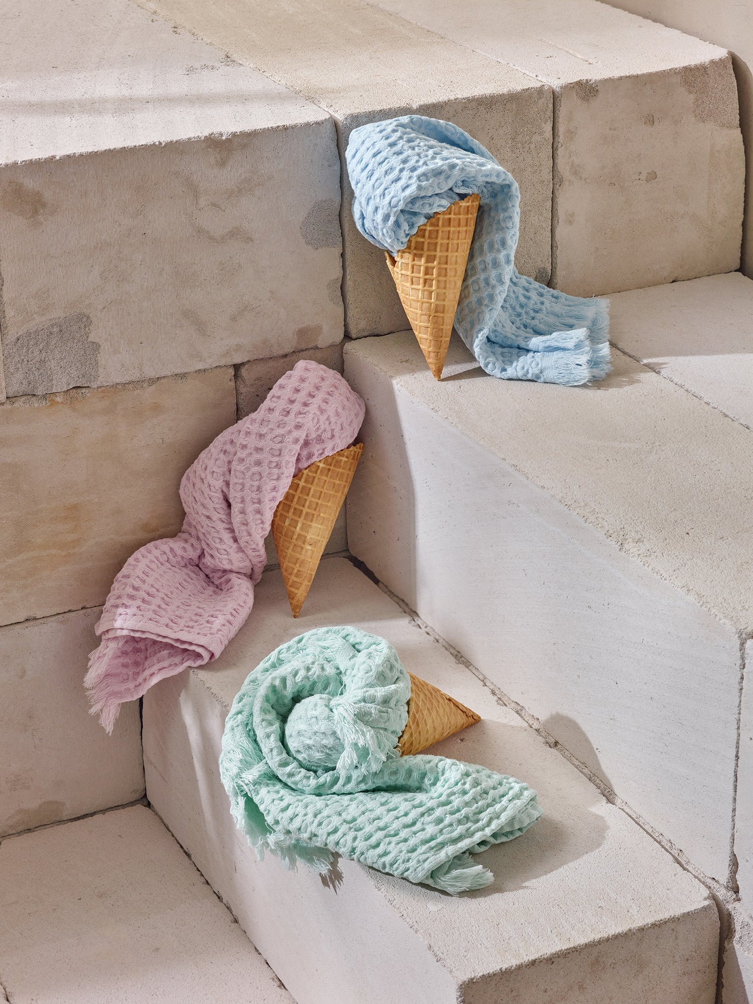 Nanson vohveli-käsipyyhkeet kesäisessä kuvassa aseteltuna jäätelövohveleihin.