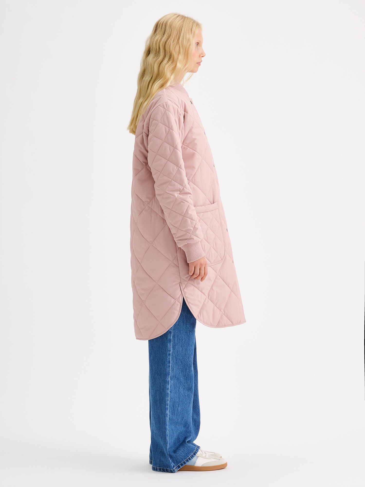 Nanson naisten Midi Tikkitakki pudotetulla olkalinjalla ja kevyellä vanulla. Takin pääntiellä ja hihansuissa on mukava neulosresori ja edessä nepparikiinnitys sekä päällitaskut. Kuvattuna mallin päällä sivusta.