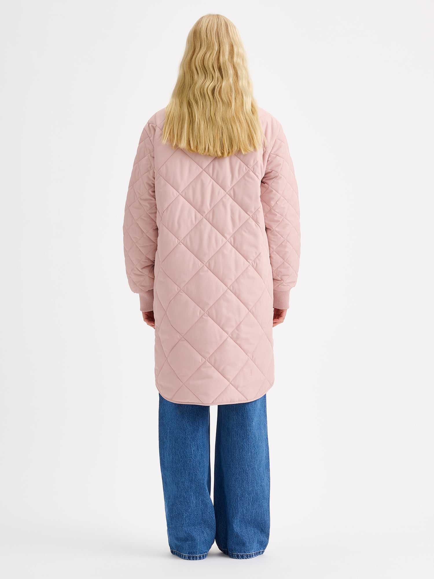 Nanson naisten Midi Tikkitakki pudotetulla olkalinjalla ja kevyellä vanulla. Takin pääntiellä ja hihansuissa on mukava neulosresori ja edessä nepparikiinnitys sekä päällitaskut. Kuvattuna mallin päällä takaa.