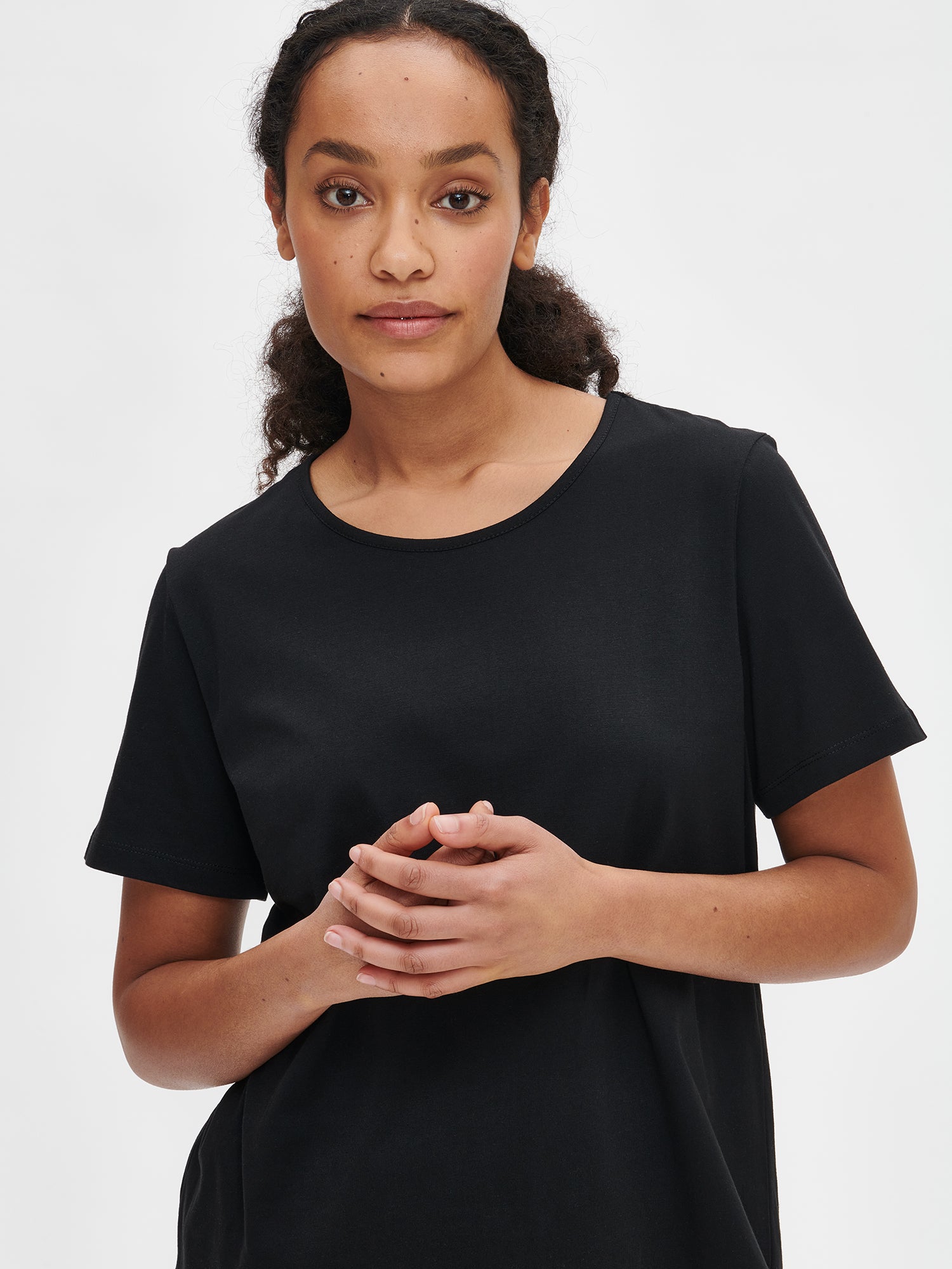 Nanson naisten kuosillinen musta Hetki- t-paita pyöreällä pääntiellä ja pyöristetyllä helmalla mallin päällä lähikuvassa.