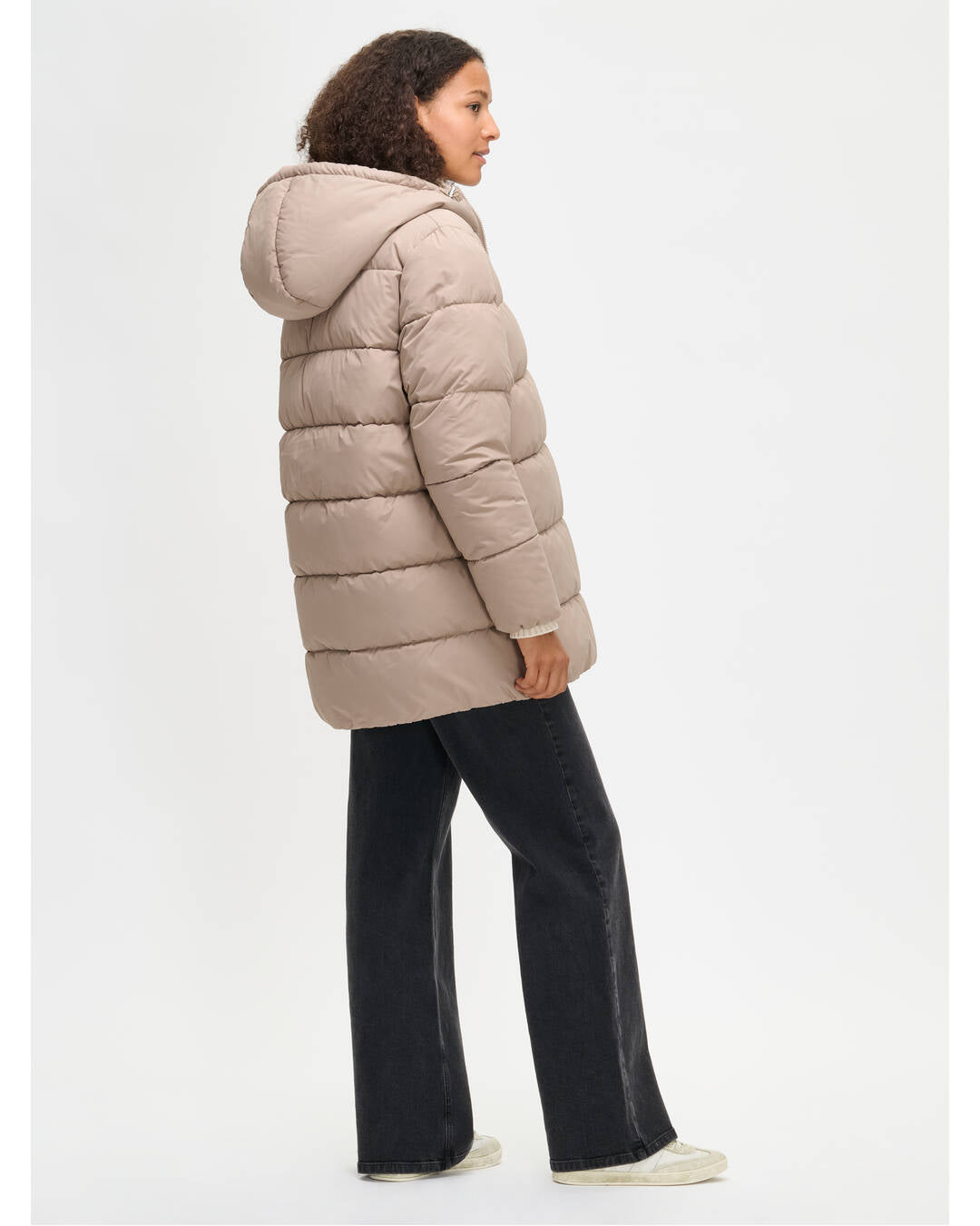 Lämmin ja muhkea beige Lumi-toppatakki miellyttävän kevyellä vanuvuorella. Mallin päällä kuvattuna takaa.