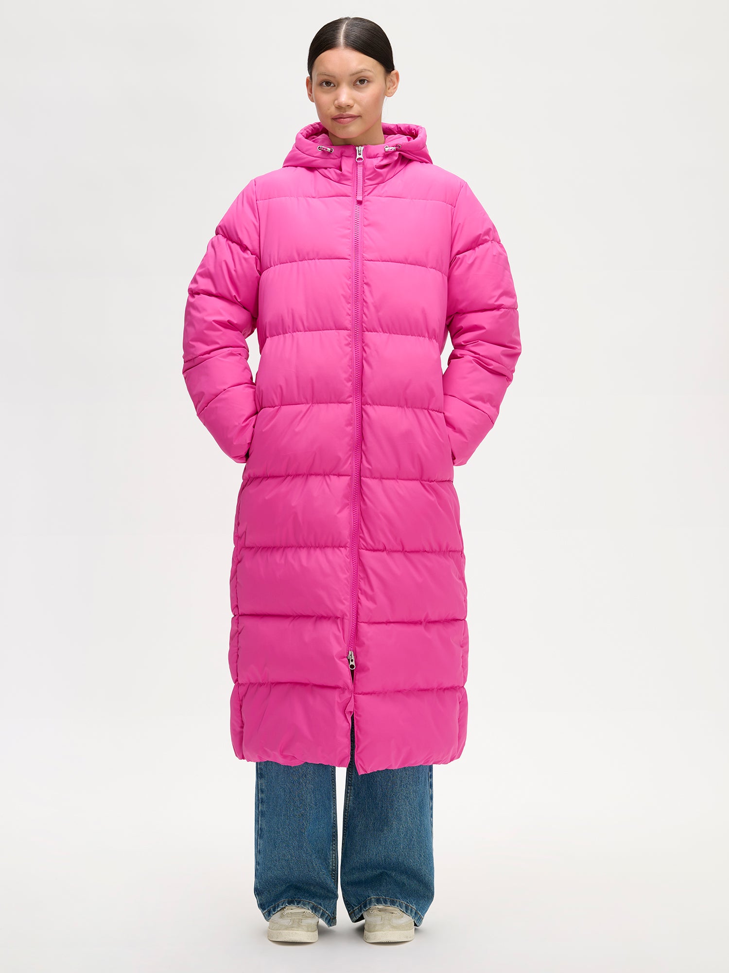 Lämmin ja muhkea pitkä pinkki Lumi-toppatakki miellyttävän kevyellä vanuvuorella. Mallin päällä edestä.