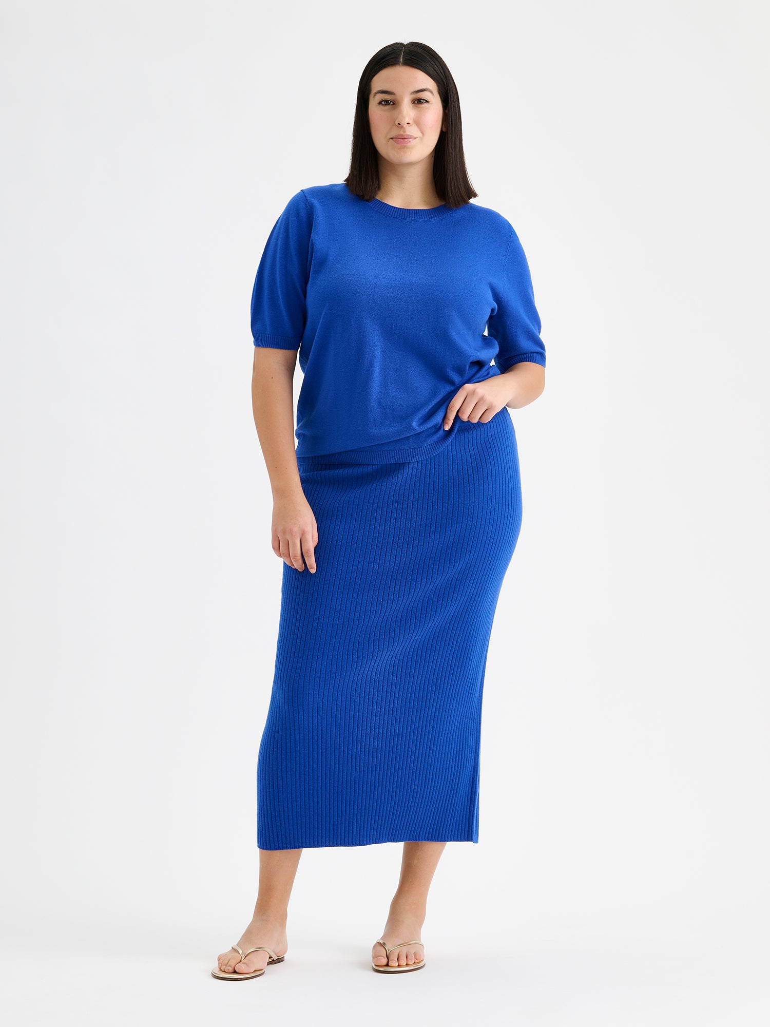 Nanson naisten lyhythihainen sininen Villis-neulepaita ja villisneulehame mallin päällä.