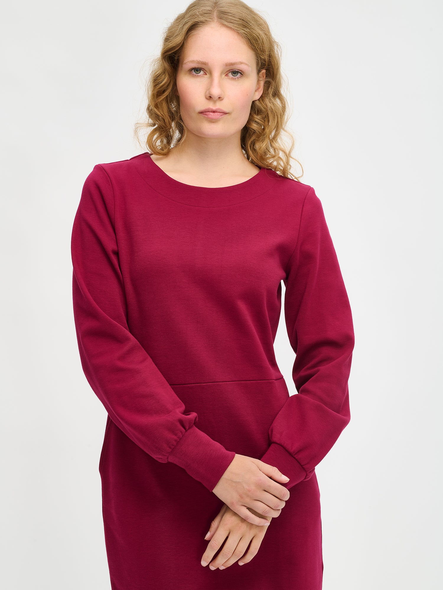 Nanson naisten viininpunainen Pauliina-mekko mallin yllä lähikuvassa, venepääntie, pitkät hihat ja vyötärösauma näkyvissä paksummassa interlock-neuloksessa.