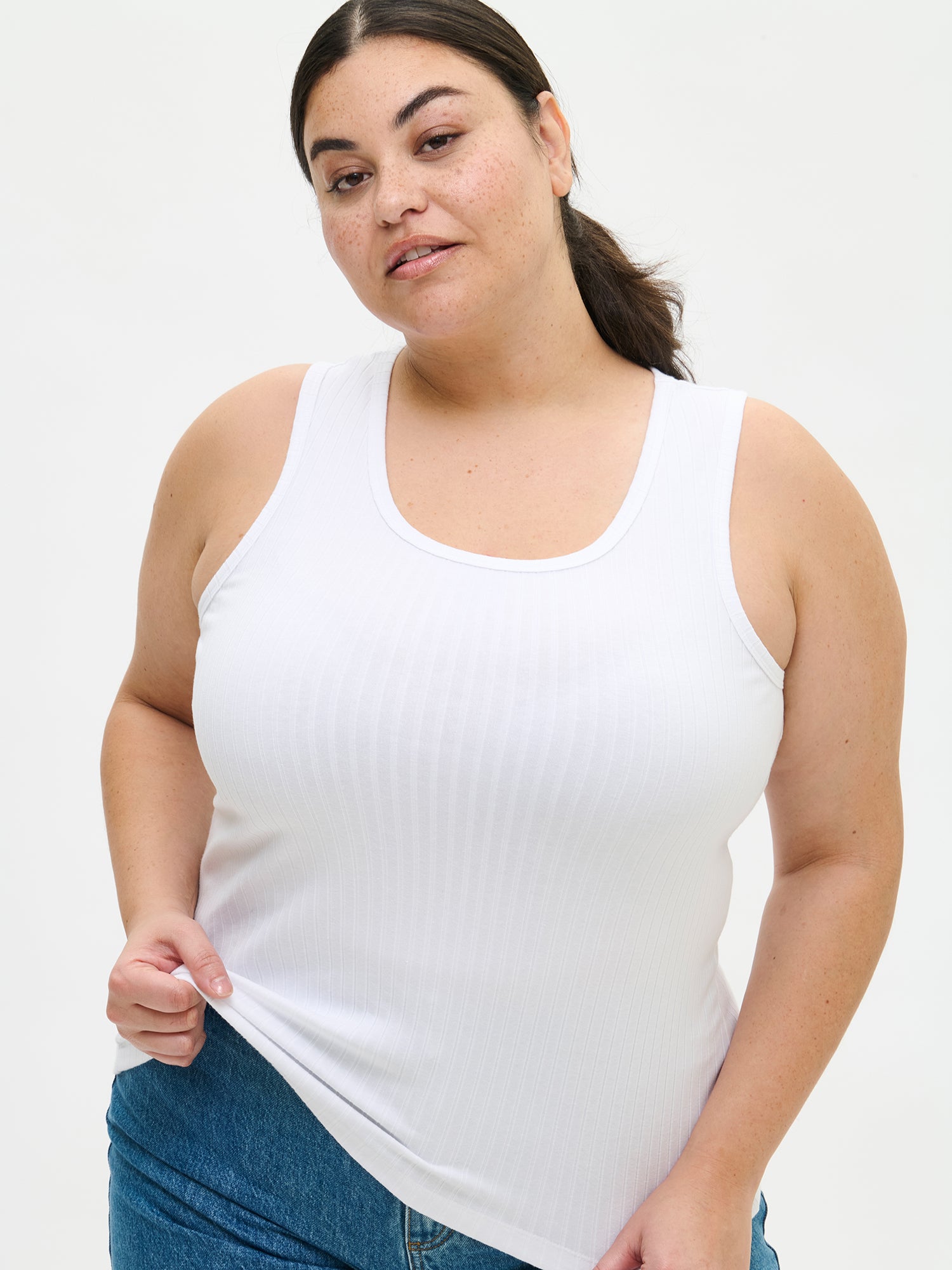 Nanson naisten ajaton valkoinen hihaton Seri-toppi pyöreällä pääntiellä ja suoralla, lantiolle ulottuvalla helmalla, plus size -mallin yllä edestä lähikuvassa.