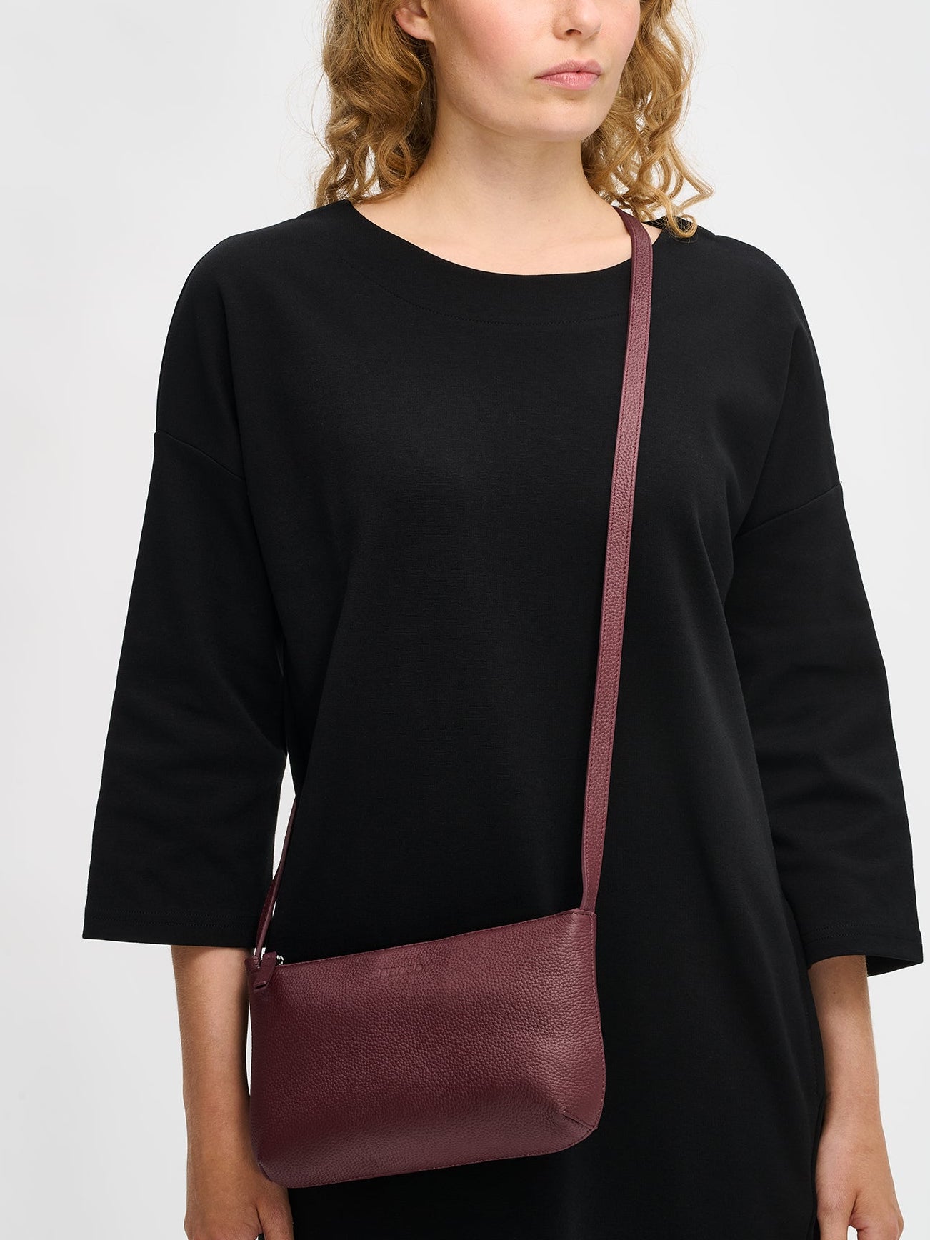 Nanson tyylikäs tumma viininpunainen Naru- olkalaukku, mallin olalla.