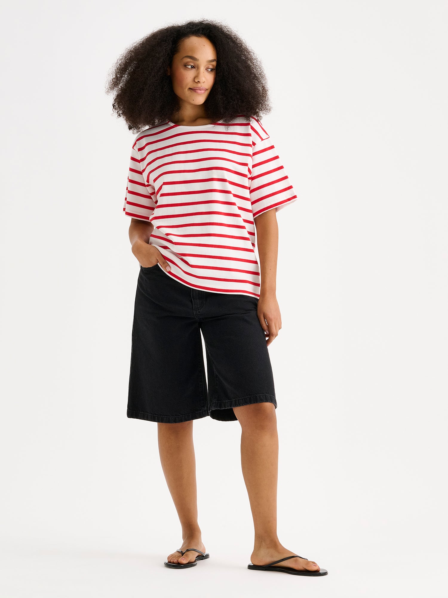Nanson naisten mukavat, rennosti istuvat Levee-shortsit mallin päällä punavalkoisen raidallisen t-paidan kanssa.