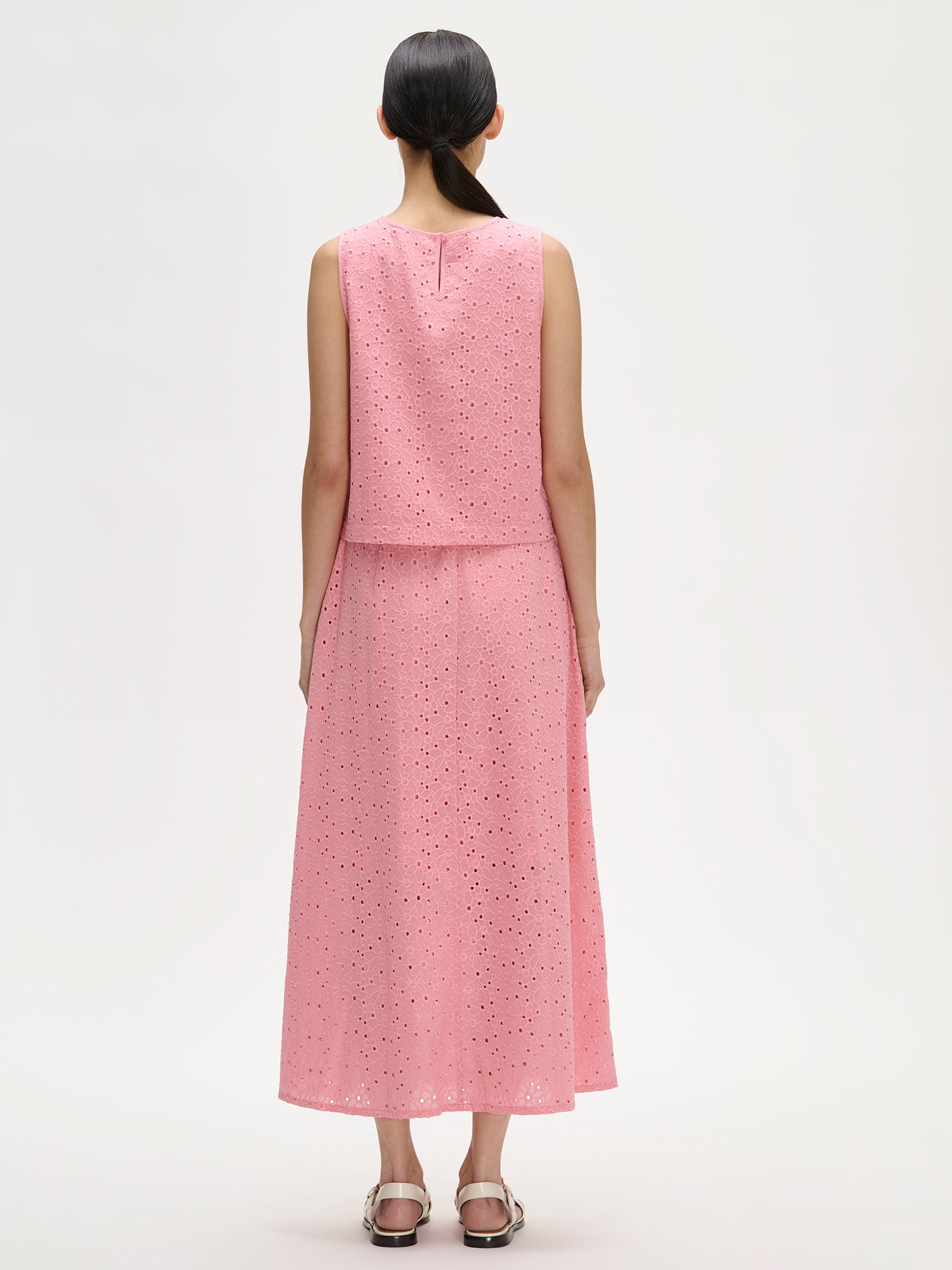 Nanson naisten kaunis vaaleanpunainen brodeerattu Nuppu-pusero Nuppu-hameen kanssa mallin päällä takaa kuvattuna.