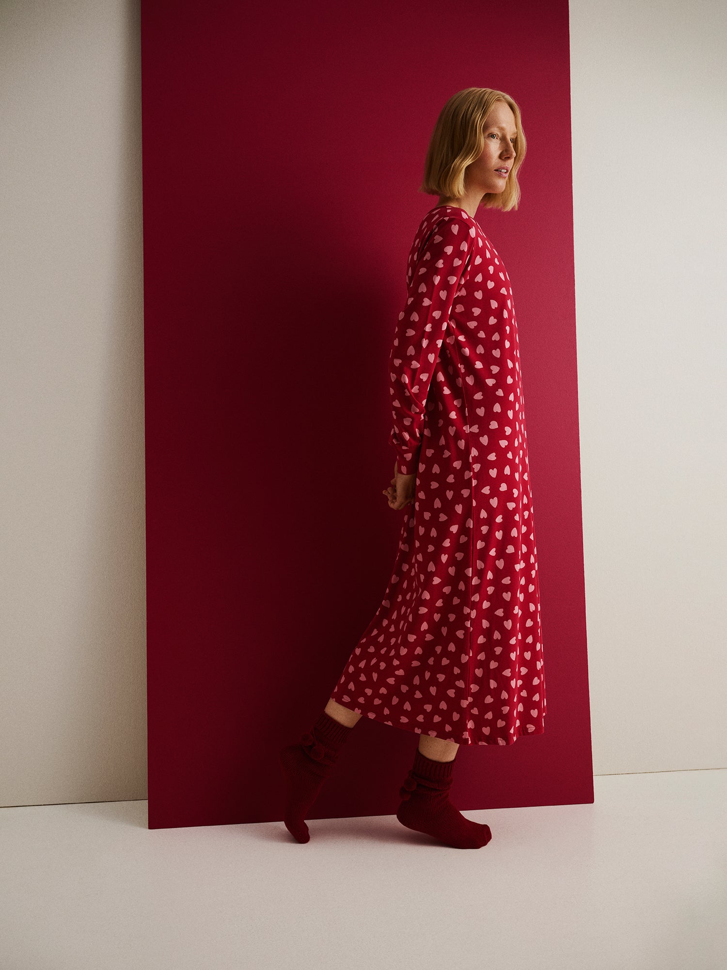 Nanso naisten kuosillinen pitkä Amor-yöpaita pitkillä hihoilla ja pyöreällä pääntiellä, mallin päällä sivusta kuvattuna.