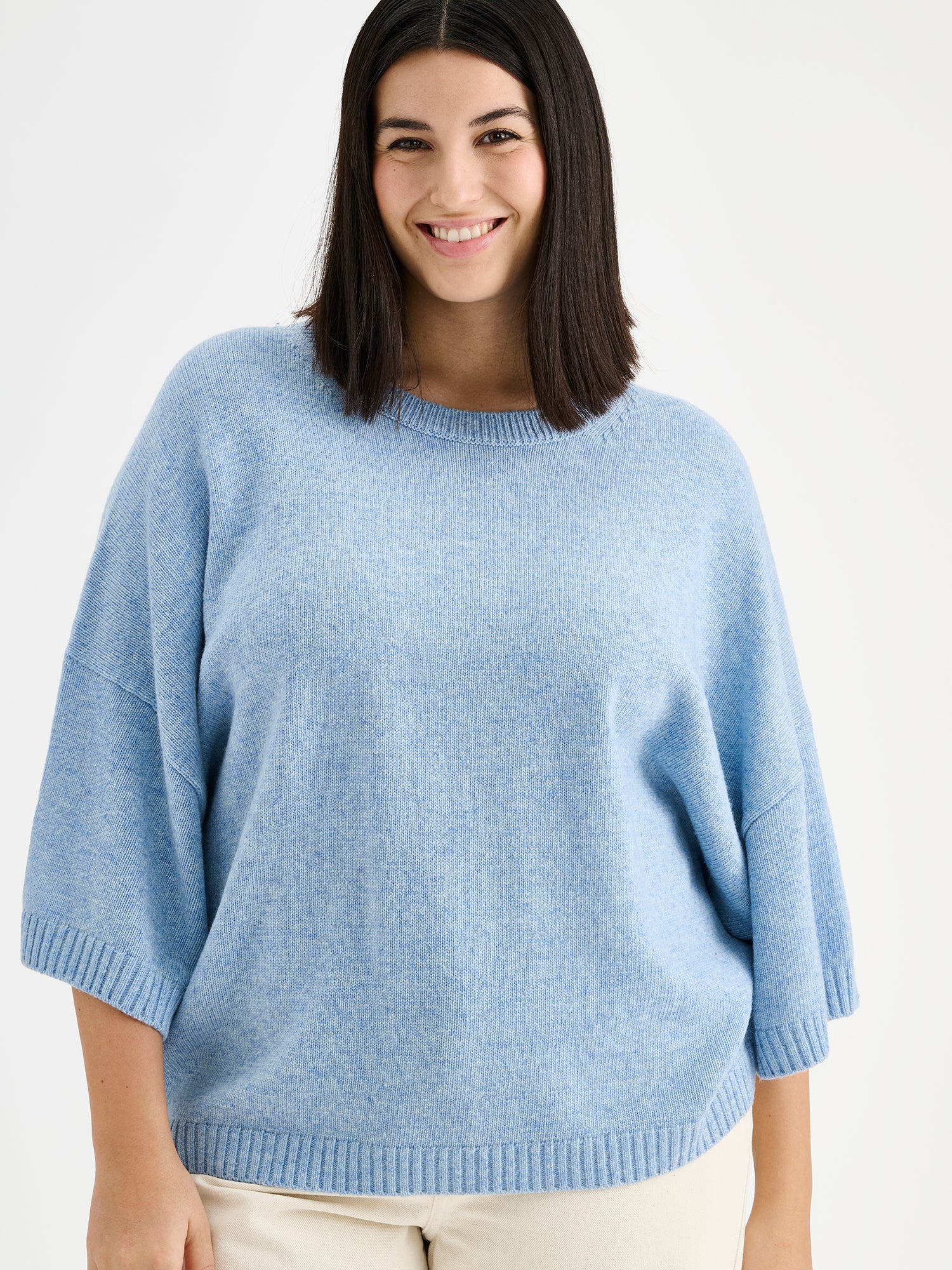 Nanson vaaleansininen lyhythihainen Lana neulepusero mallin päällä vaaleiden farkkujen kanssa, lähikuvassa.