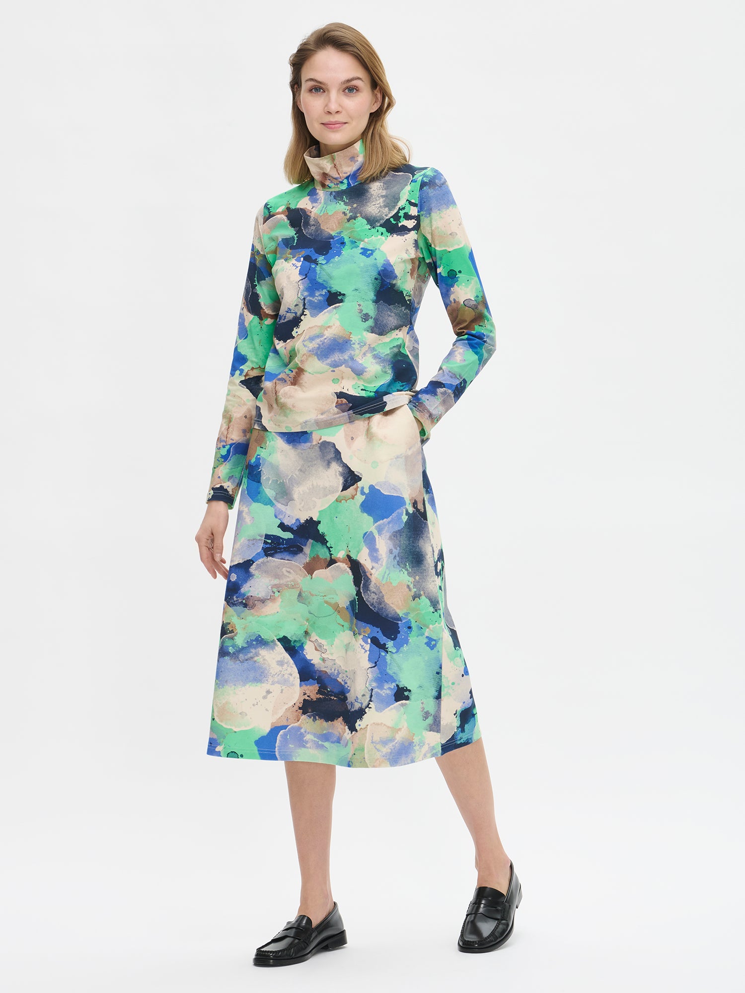 Naisten tyylikäs Sirius-hame näyttävällä abstraktilla kuosilla on malliltaan kauniin A-linjainen ja erittäin mukava päällä. Hameessa on taskut. Kuvassa mallin päällä.