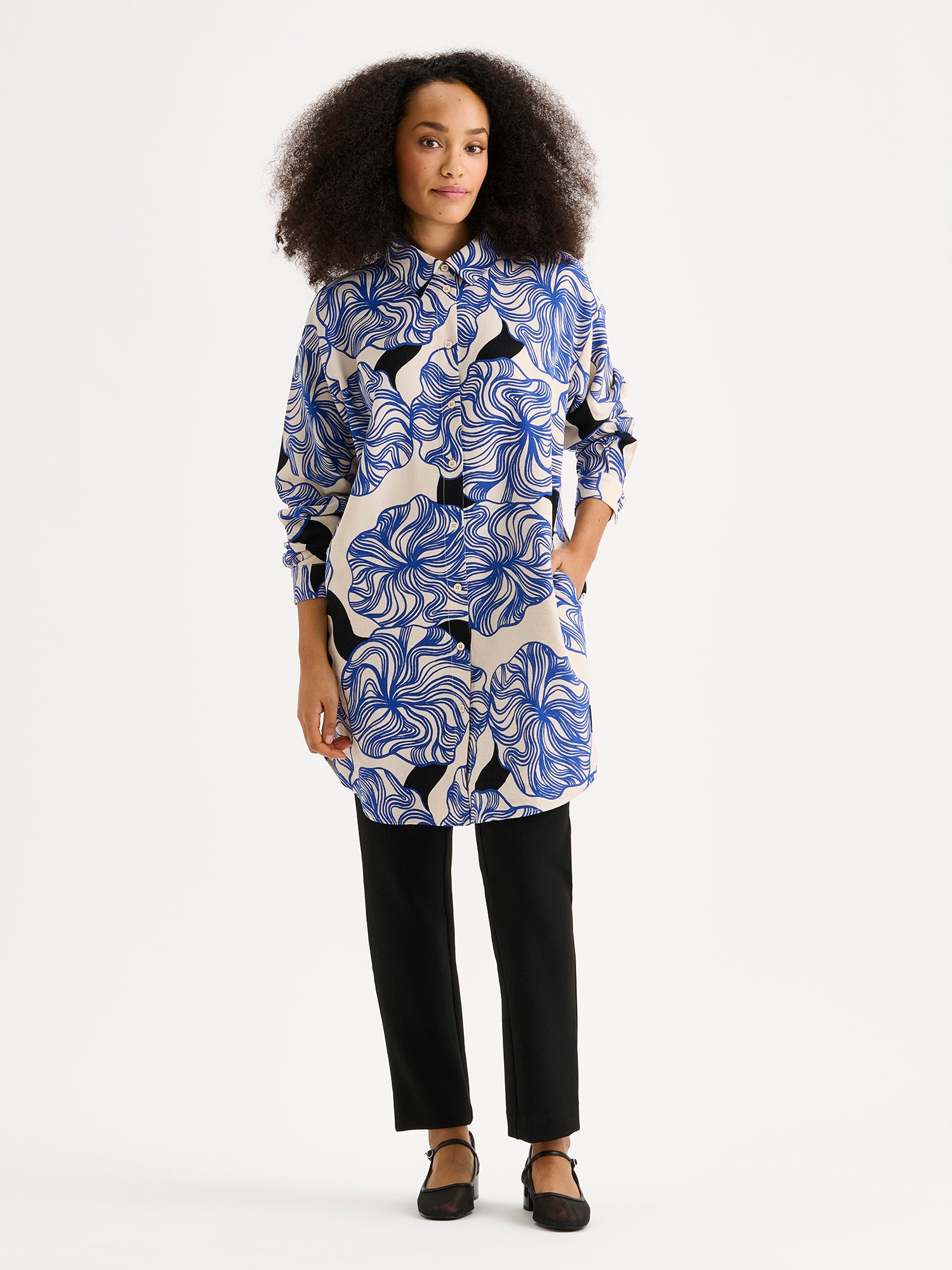 Nanson naisten Kosmo-kauluspaidassa yhdistyy klassinen malli ja näyttävä sinisävyinen kuosi. Paidassa on klassinen kaulusmalli, täyspitkät hihat, sivutaskut ja napitus edessä. Kuvassa mallin päällä.