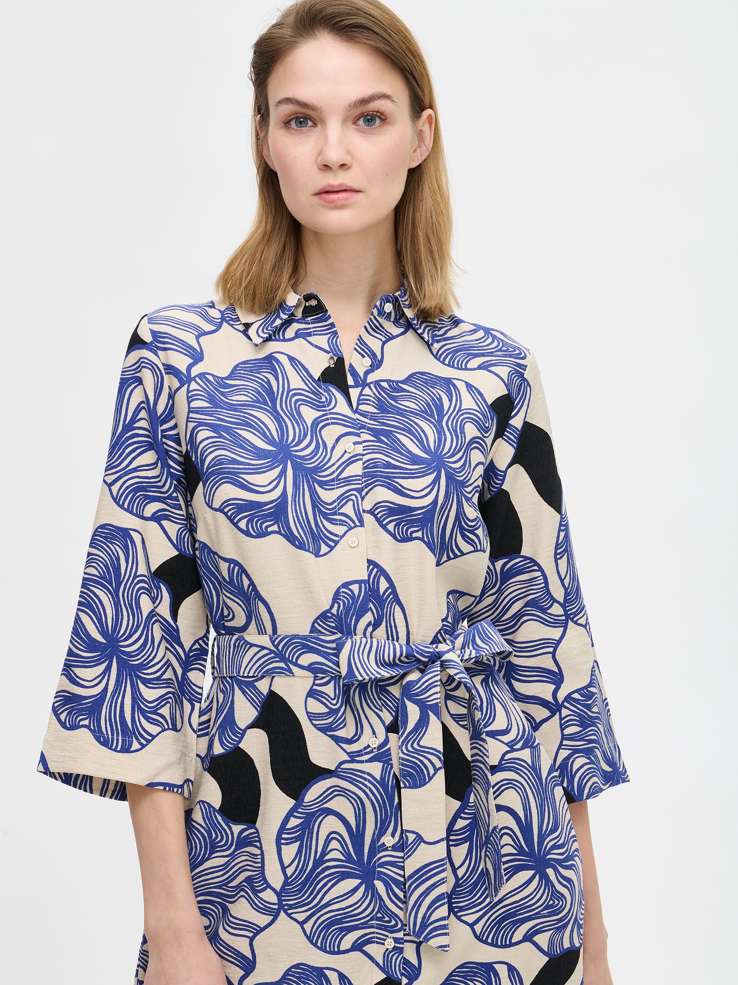 Naisten Kosmo-mekossa yhdistyy pelkistetty klassinen malli ja näyttävä sinisävyinen kuosi. Mekon istuvuus on helppo säätää sopivaksi vyöllä ja siinä on myös käytännölliset taskut. Kuvassa mallin päällä läheltä kuvattuna.