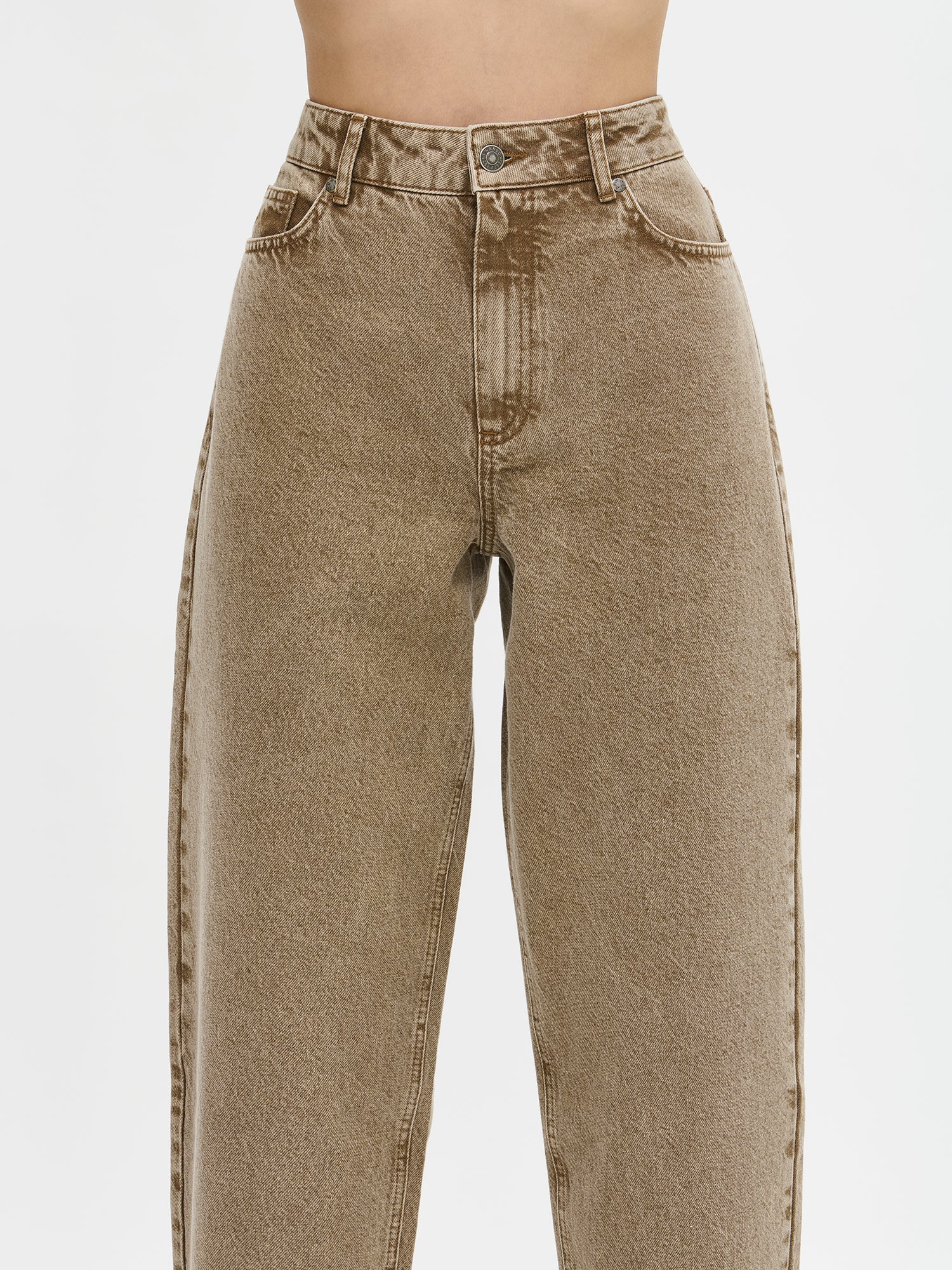 Nanson naisten barrel leg- tyyliset väljät ruskeat Rento-farkut. Farkuissa on normaalikorkuinen vyötärö, edessä vetoketju ja nappikiinnitys. Lahkeet ovat väljät ja kapenevat hieman kohti lahkeensuuta. Lähikuva mallin päällä edestä.