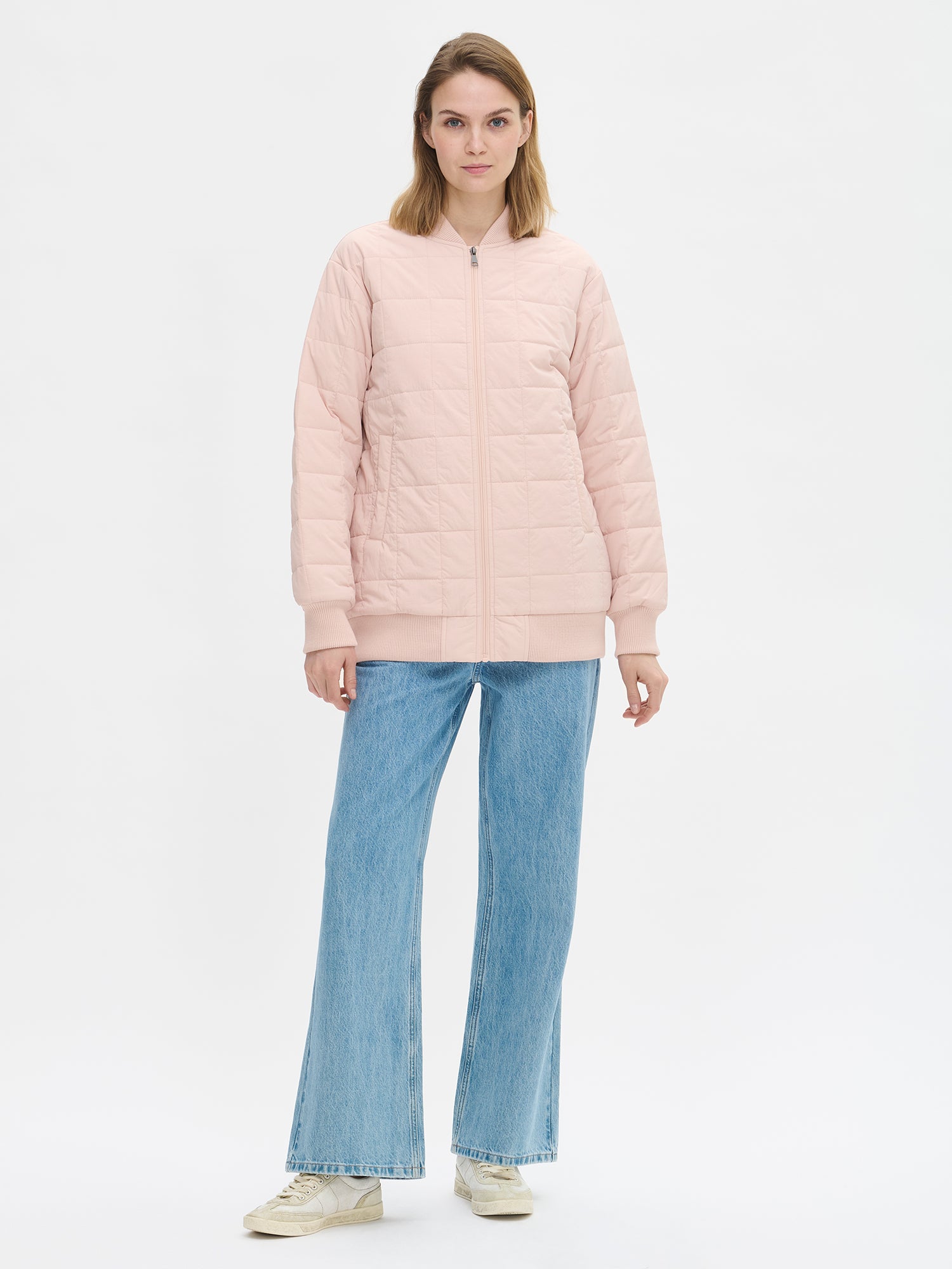 Nanson naisten rento Merje bomber tikkitakki kevyellä vanulla. Takin pääntiellä, hihansuissa ja helmassa on neulosresori. Edessä on vetoketju ja taskut. Takin olkalinja on pudotettu. Mallin päällä kiinni farkkujen kanssa kuvattuna.