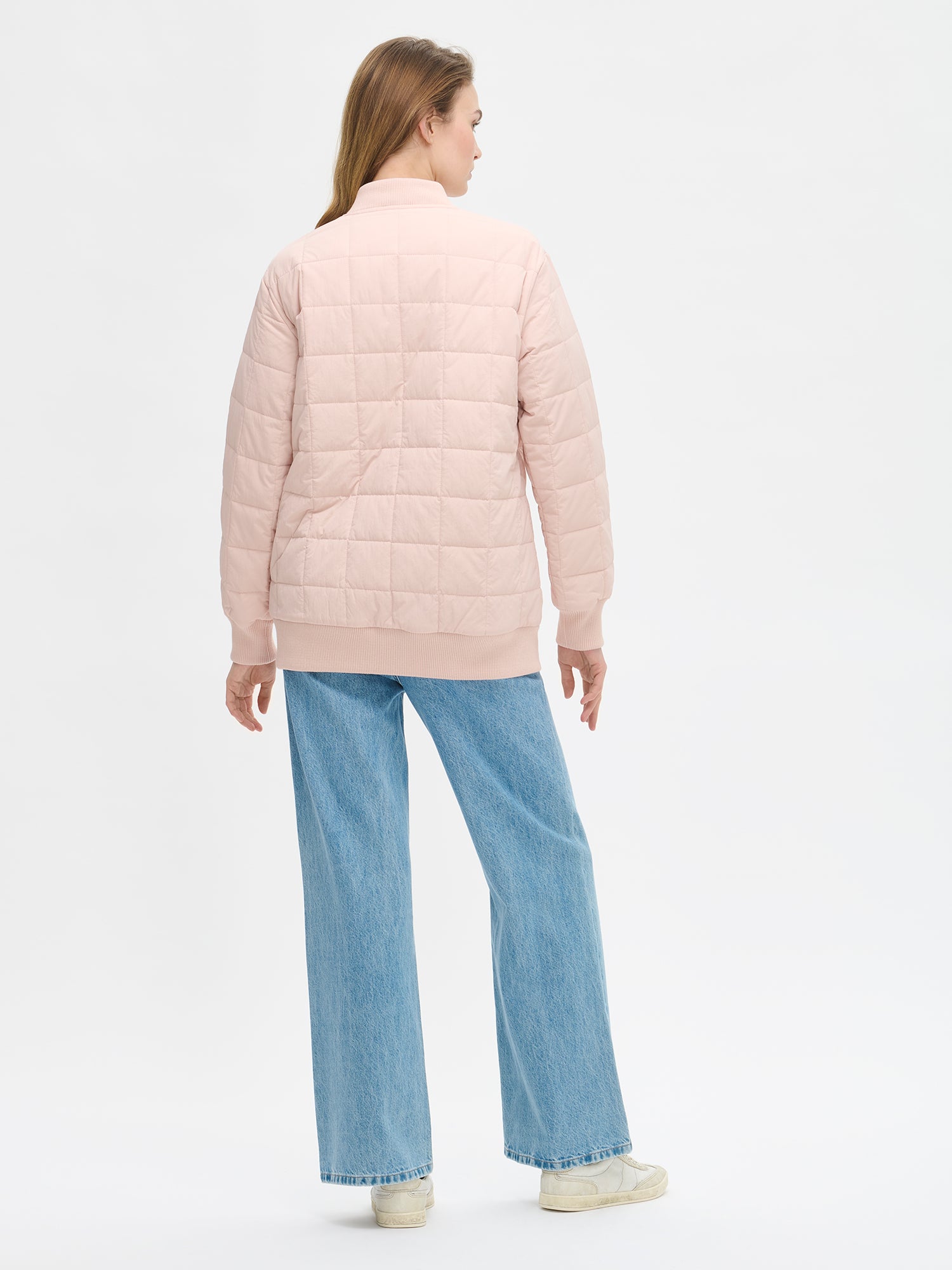 Nanson naisten rento Merje bomber tikkitakki kevyellä vanulla. Takin pääntiellä, hihansuissa ja helmassa on neulosresori. Edessä on vetoketju ja taskut. Takin olkalinja on pudotettu. Mallin päällä takaa farkkujen kanssa kuvattuna.