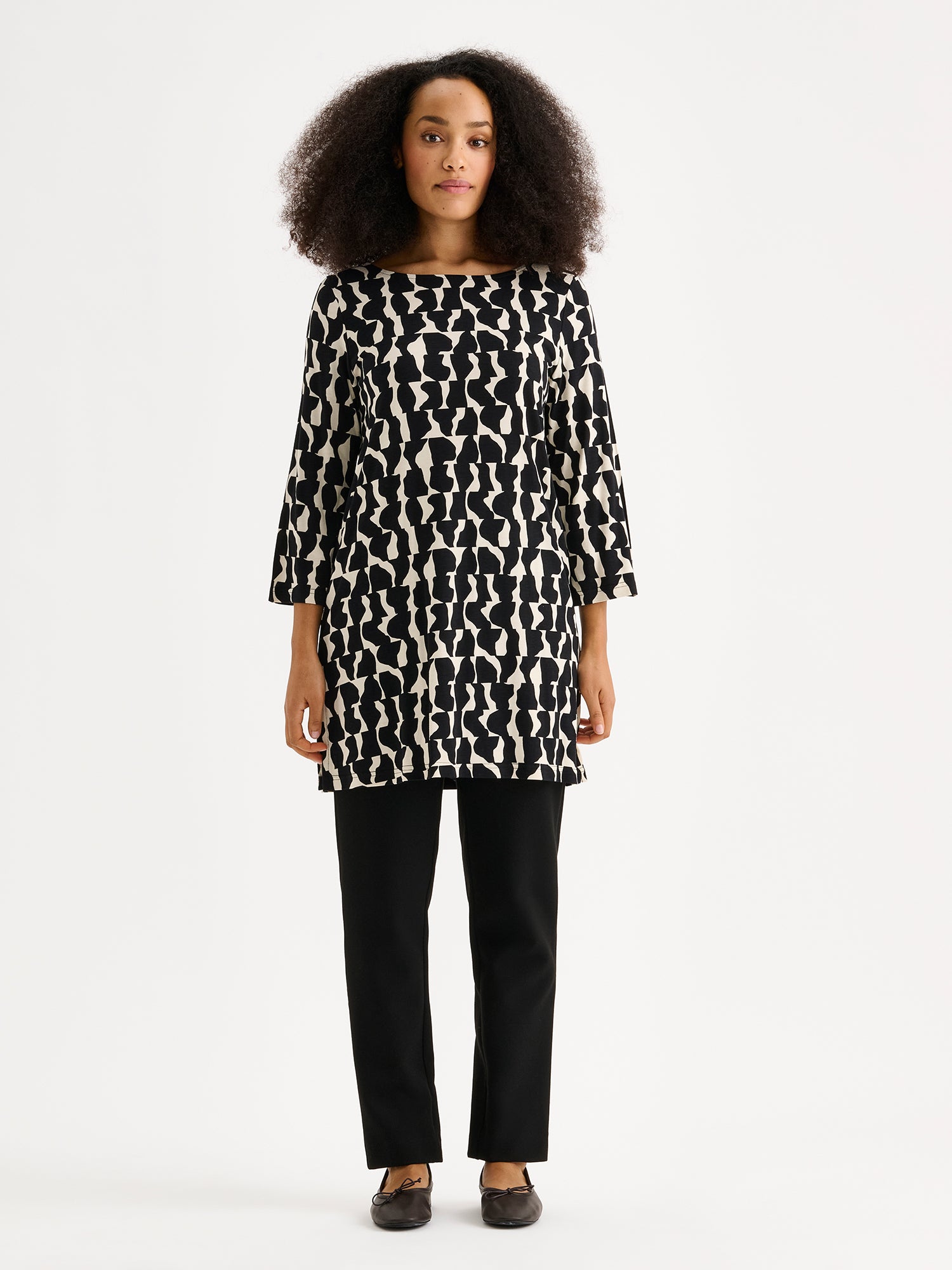 Naisten kuosillinen Pieni Soraja-tunika mallin päällä mustien housujen kanssa.