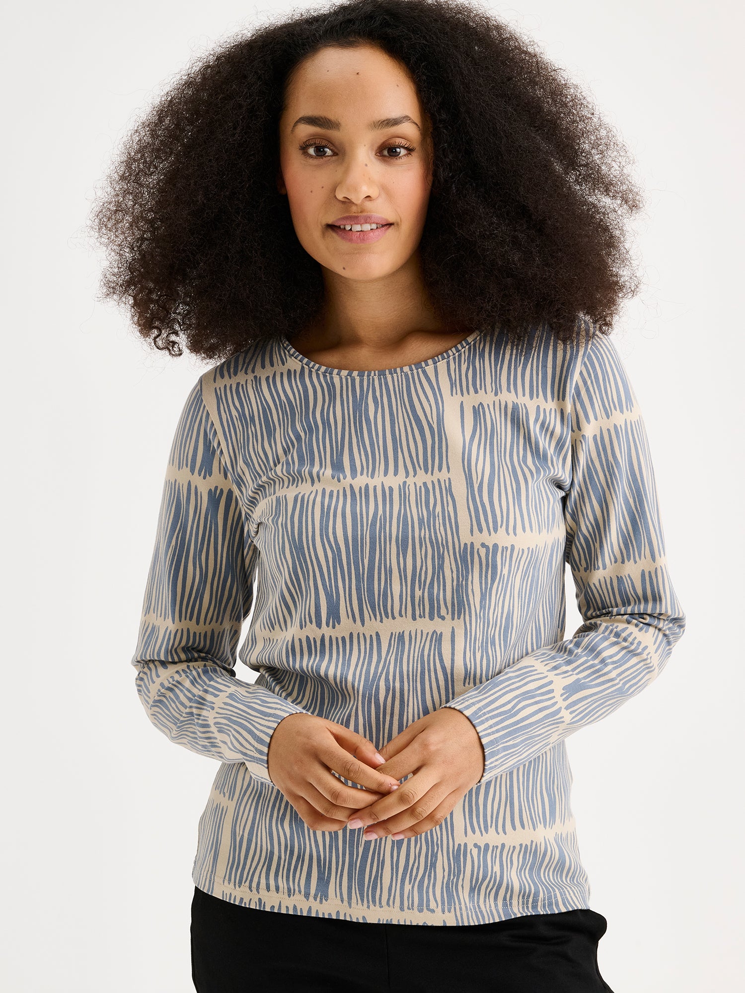 Naisten kaunis ja käytännöllinen sininen Ruoko-trikoopusero kauniilla harmonisella kuosilla mallin päällä lähikuvassa.