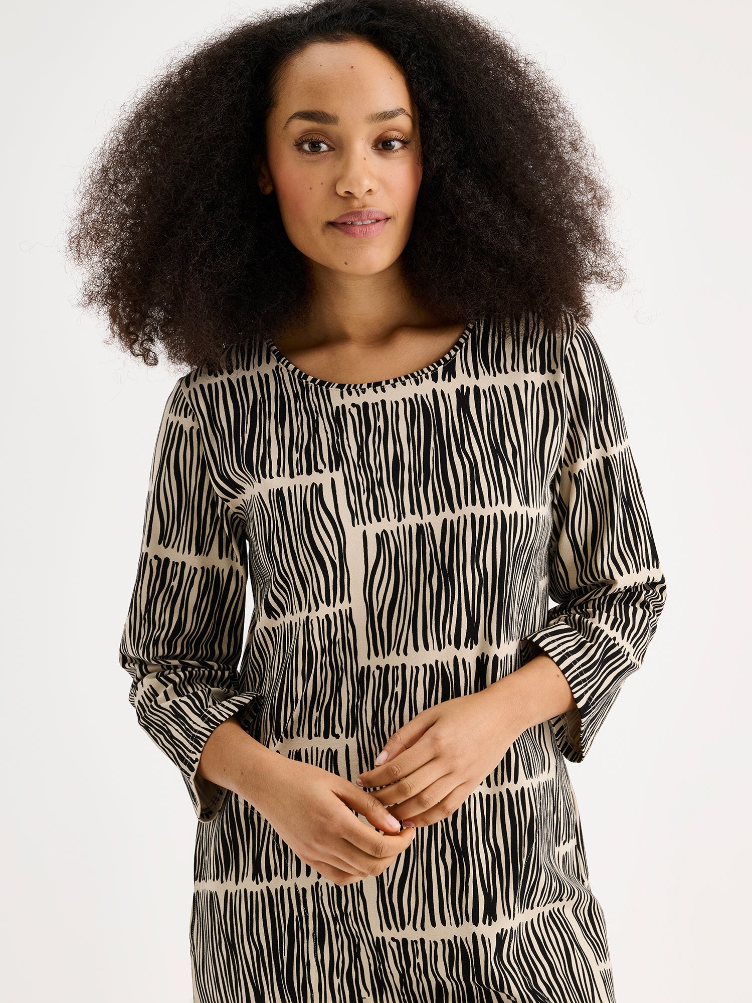 Naisten mukava ja tyylikäs Ruoko-trikoomekko hurmaavalla harmonisella kuosilla ja 3/4 pituisilla hihoilla mallin päällä lähikuvassa.