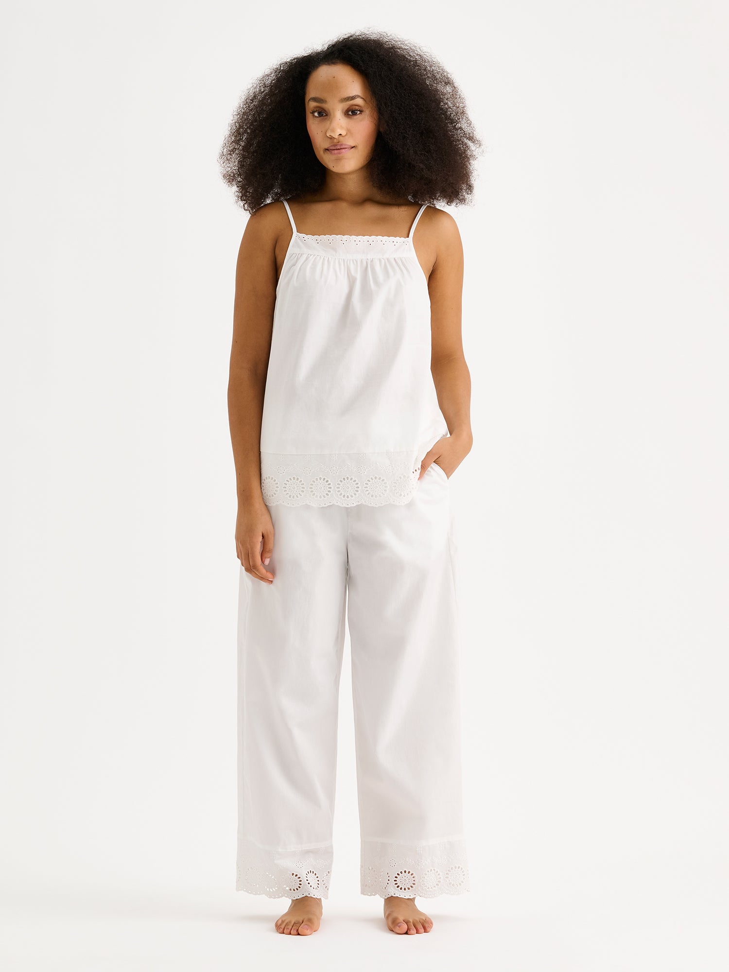 Nanson naisten valkoinen Juhannus-pyjamatoppi pitsiyksityiskohdilla mallin päällä saman sarjan housujen kanssa.