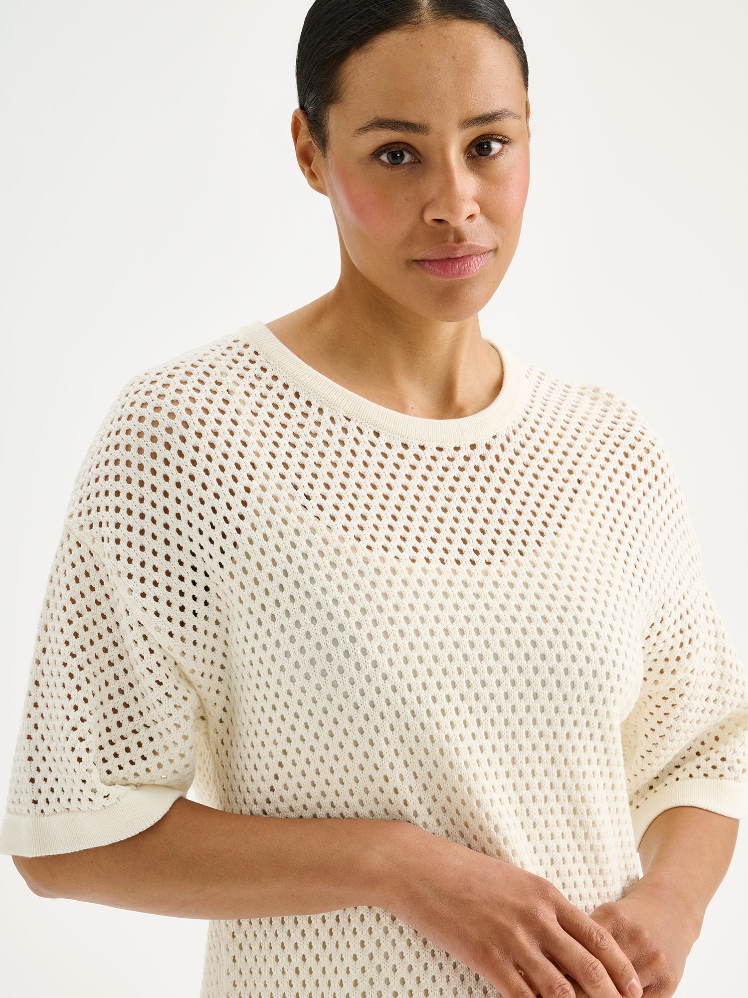 Nanson naisten trendikäs luonnonvalkoinen Aure -reikäneulemekko mallin päällä lähikuvassa.