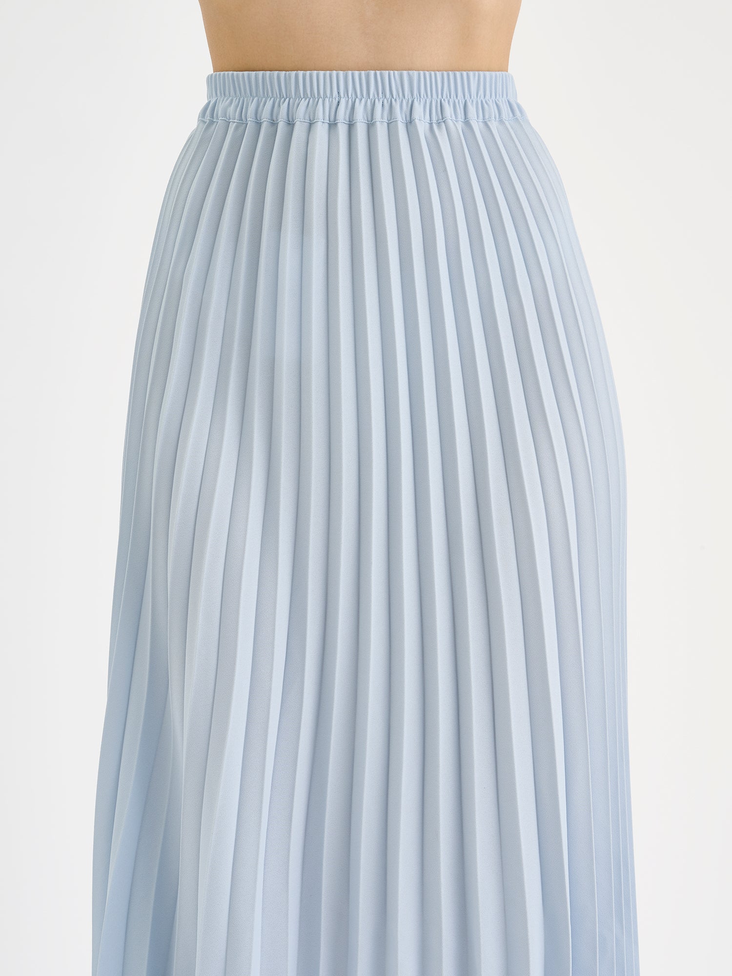 Naisten kauniisti laskeutuva sininen pliseerattu Ariel-hame mallin päällä lähikuvassa.