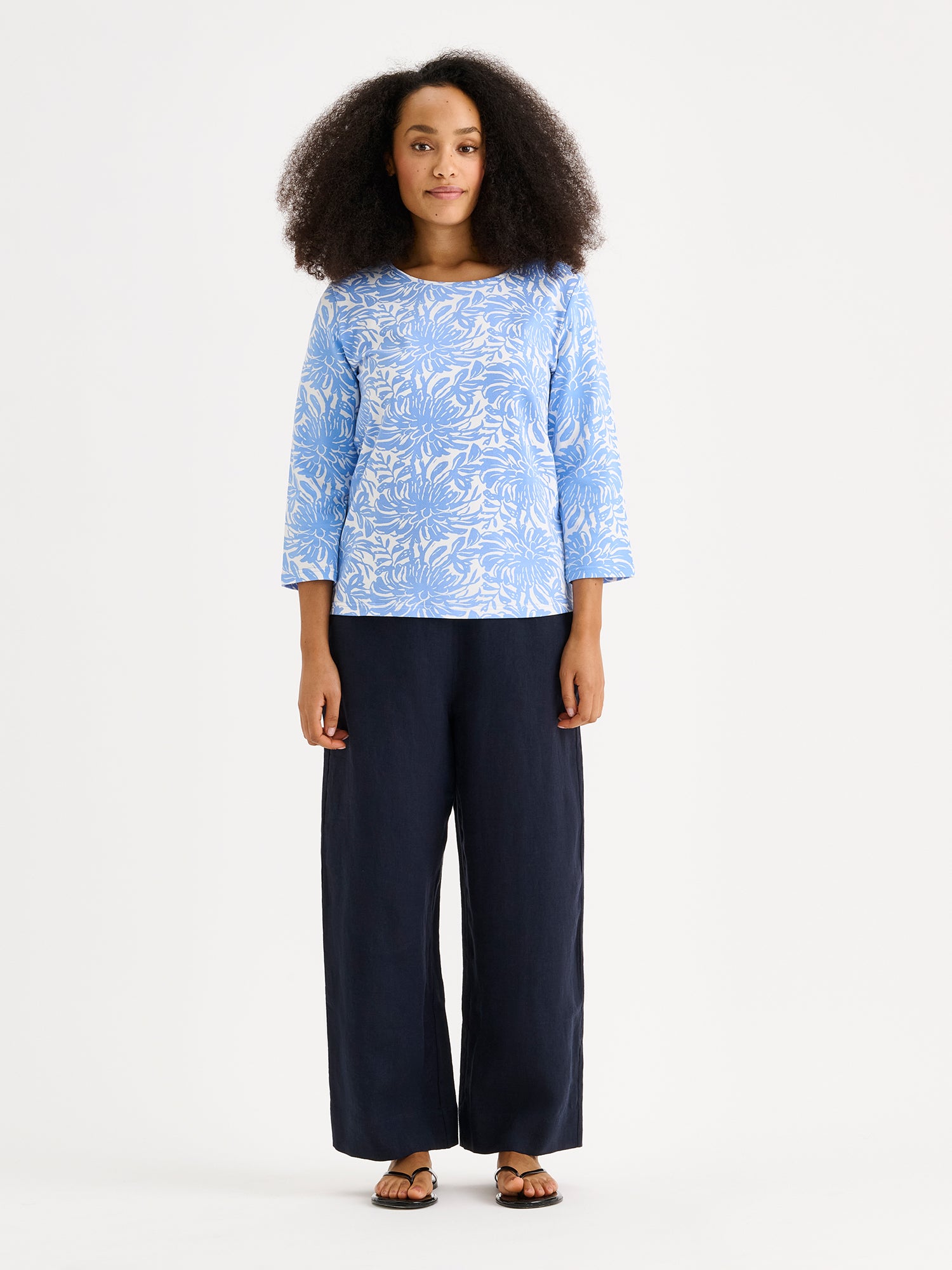 Nanson naisten kuosillinen sininen Safiiri-trikoopusero mallin päällä pellavahousujen kanssa.