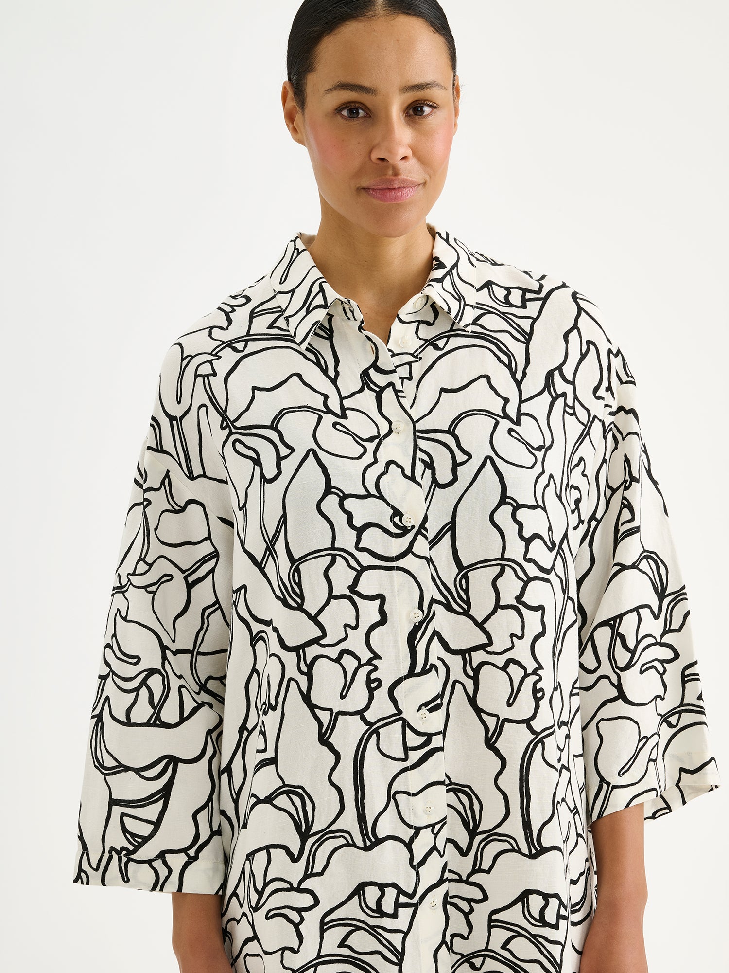 Naisten mukavan rento Iiris-paitamekko, jossa on tyylikäs ja näyttävä mustavalkoinen kukkakuosi mallin päällä lähikuvassa