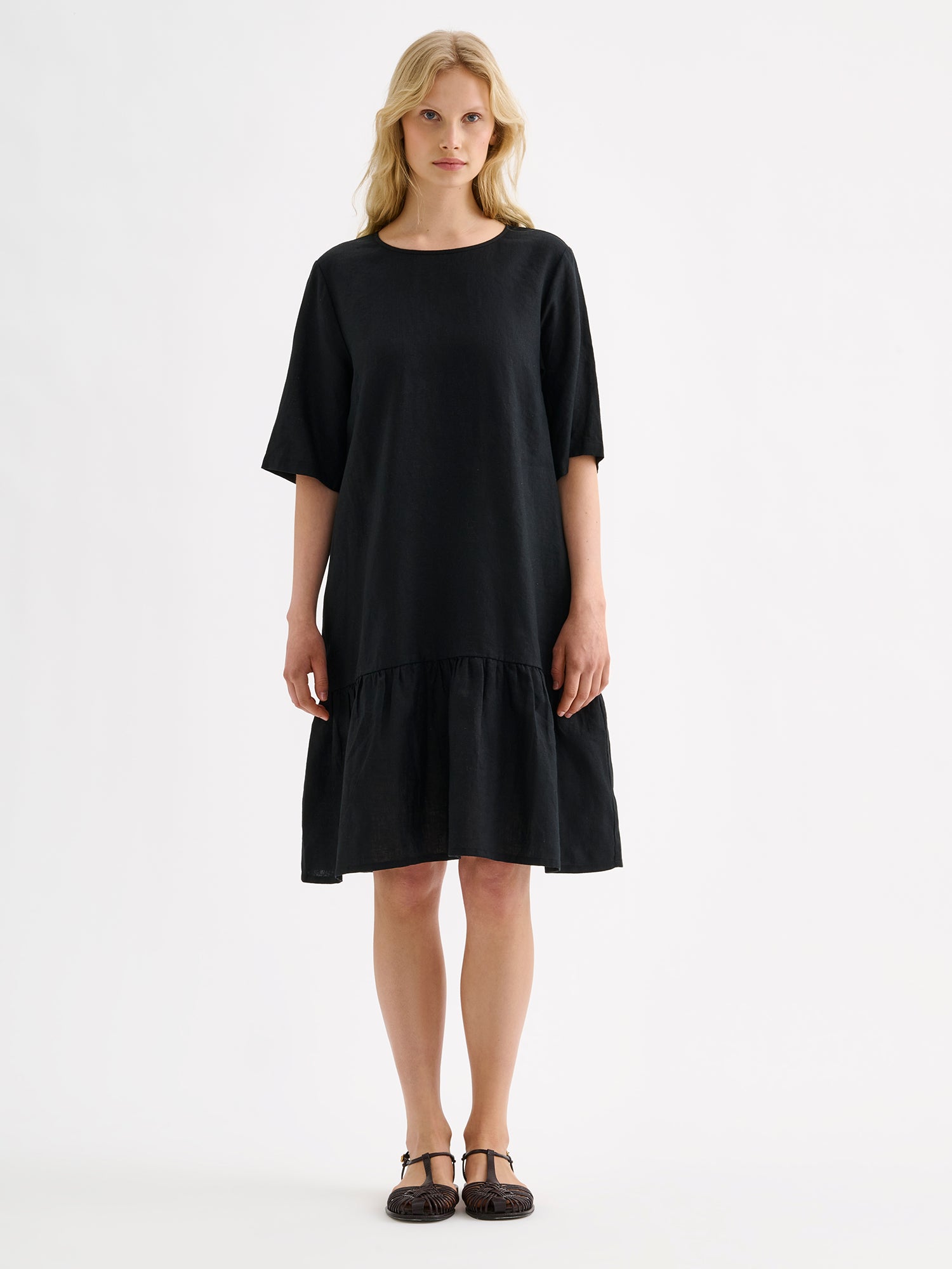 Nanson naisten kaunis ja ihanan rennon mallinen musta Liisu-pellavamekko, jonka helmassa on runsas frilla, mallin päällä sandaalien kanssa.