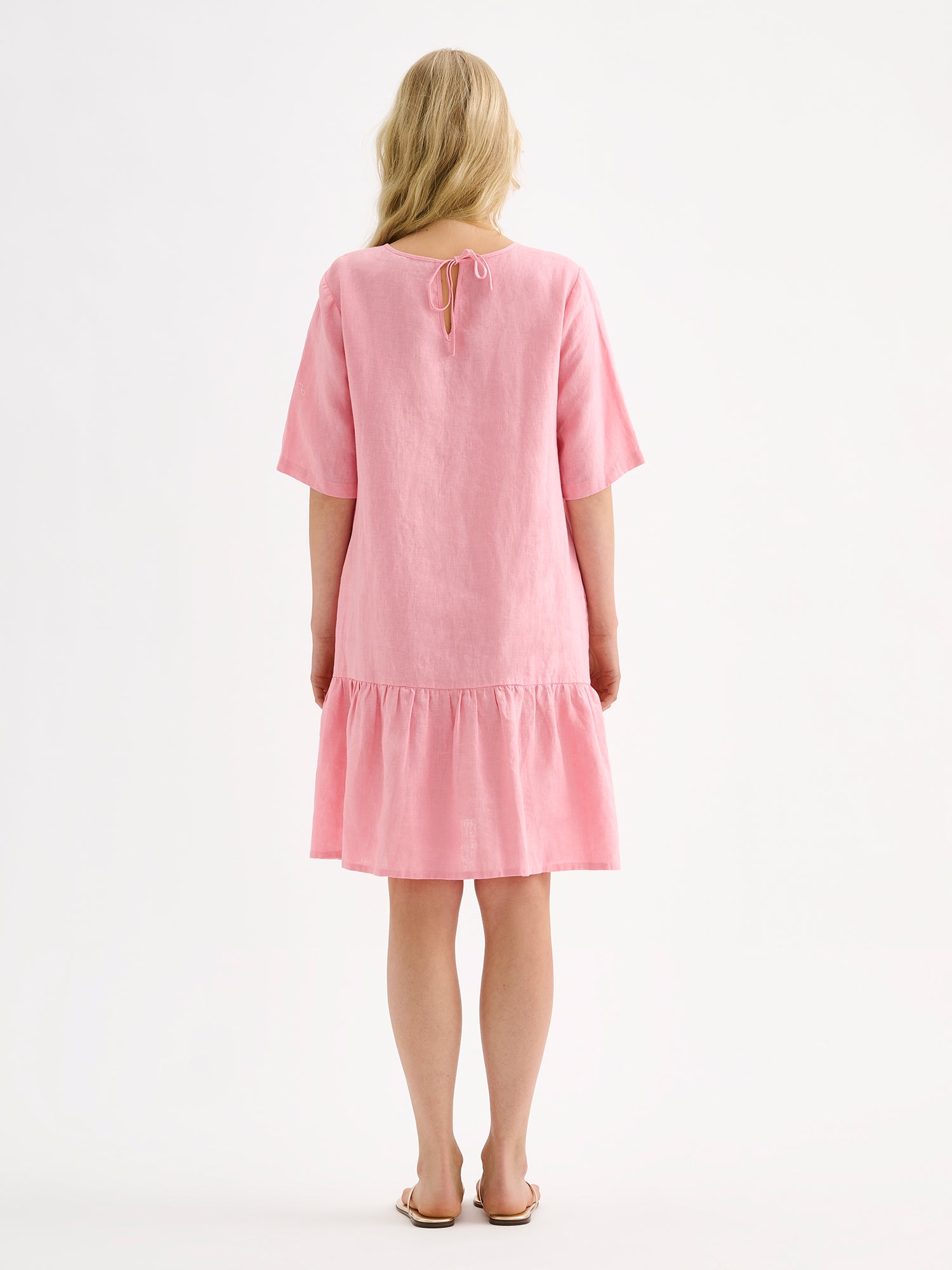 Nanson naisten kaunis ja ihanan rennon mallinen vaaleanpunainen Liisu-pellavamekko, jonka helmassa on runsas frilla, mallin päällä kuvattuna takaa.