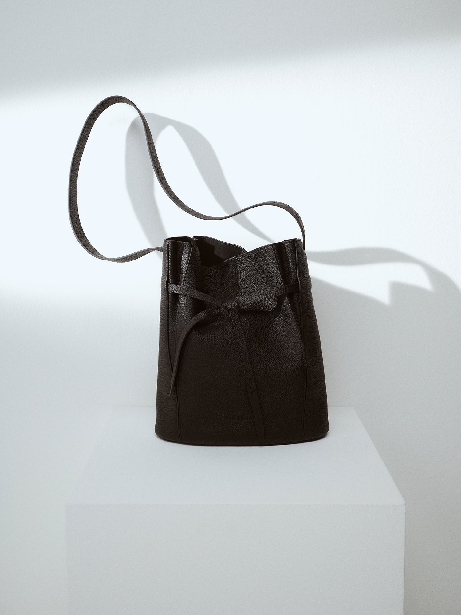 Nanson tyylikäs musta Naru Bucket- nahkalaukku. Nahkalaukussa on säädettävä olkahihna. Vuoritetussa laukussa on tasku sisäpuolella ja magneettinappi kiinnitys. Brändikuvassa kuvattuna etupuolelta.