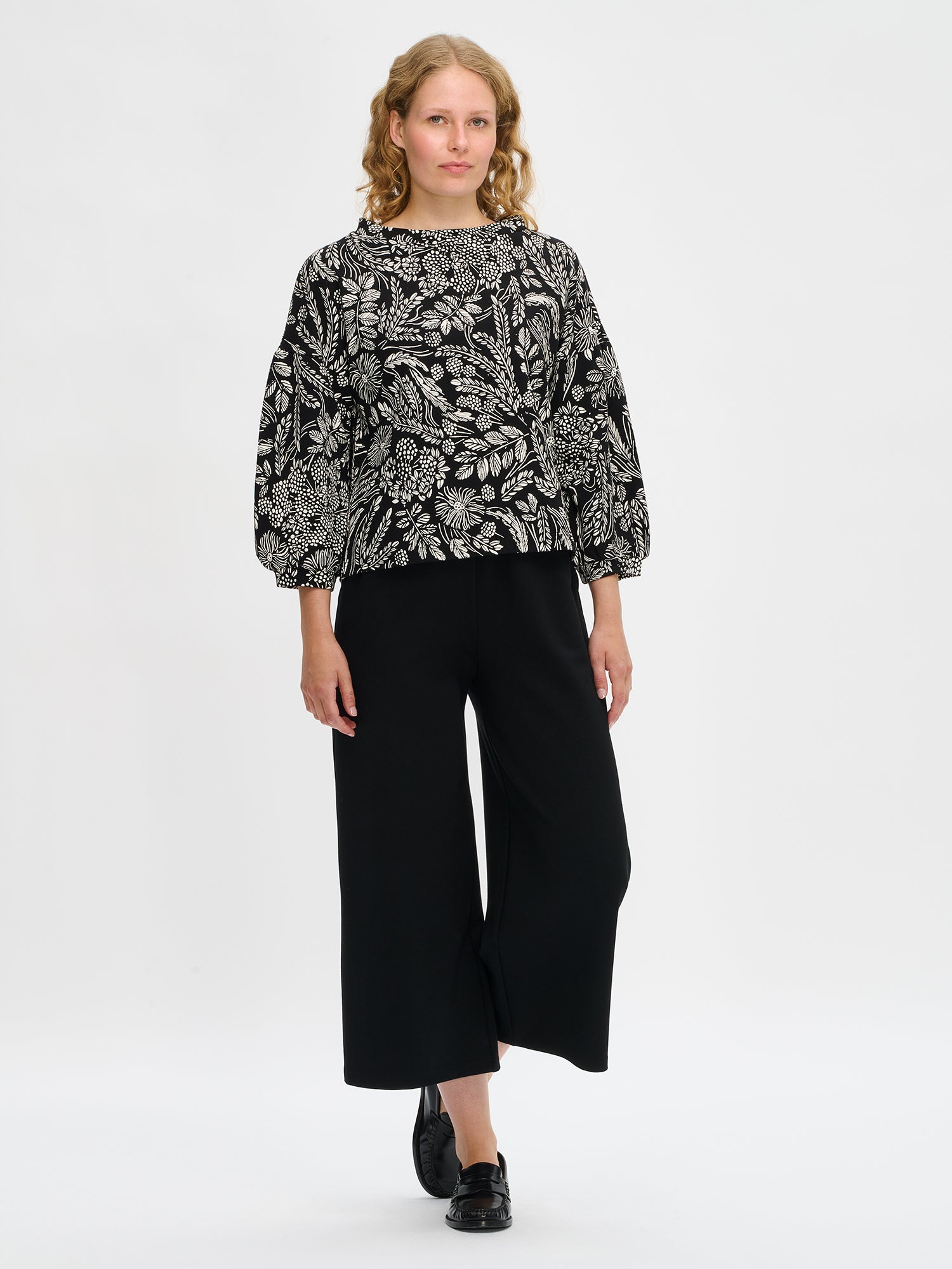 Nanson naisten mustavalkoinen Floora-pusero, venemuotoinen pystykaulus ja 3/4-hihat, mallin yllä kokokuvassa.