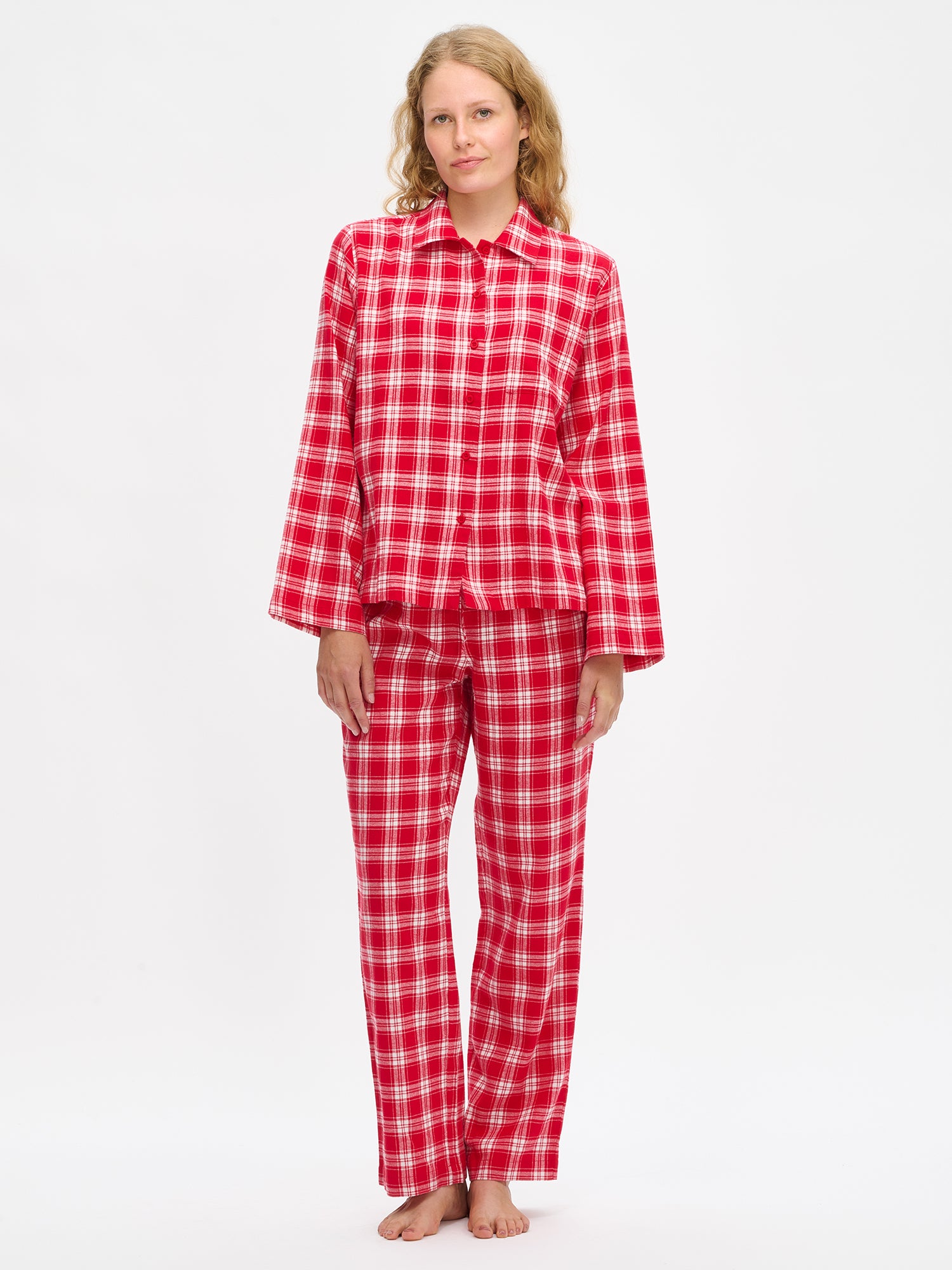 Nanson naisten punainen ruutukuosinen flanellipaita mallin yllä lähikuvassa, lantiolle ulottuva, kaulus, nappilista ja rintatasku pehmeässä puuvillaflanellikankaassa.