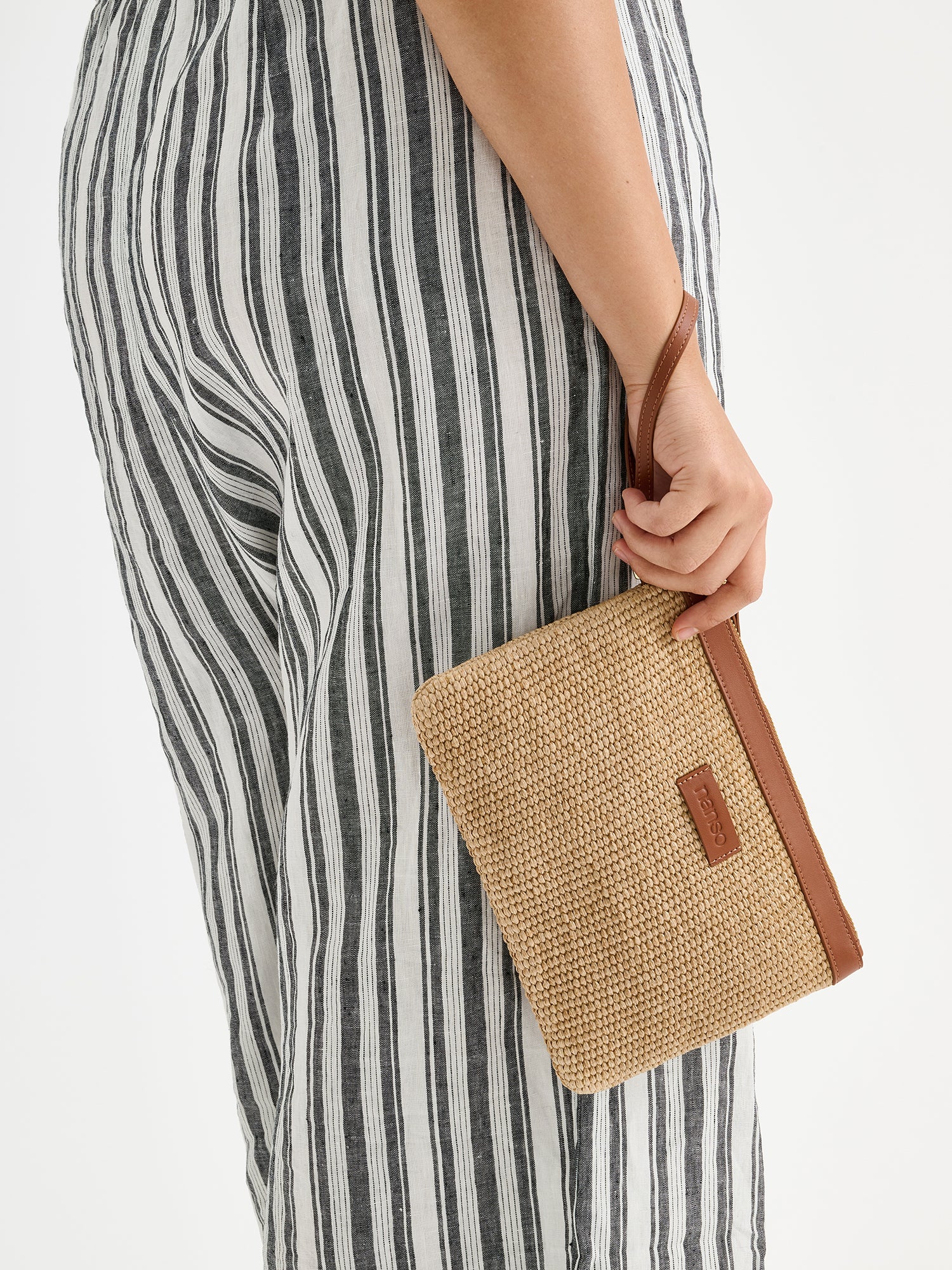 Nanson Kori Mini laukku mallin kädessä raidallisten housujen kanssa