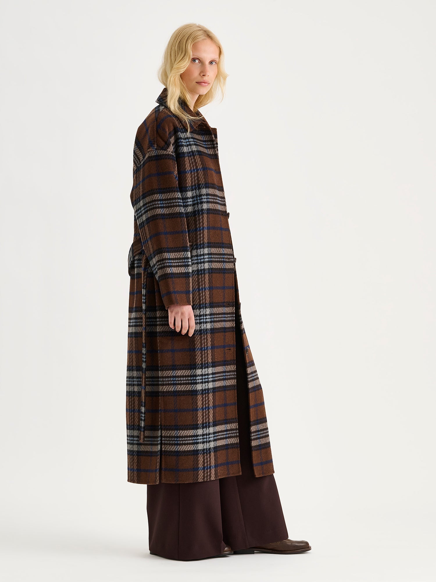 Tyylikäs ja klassinen Astrid-villakangastakki trendikkäällä ruutukuosilla, mallin päällä farkkujen kanssa.