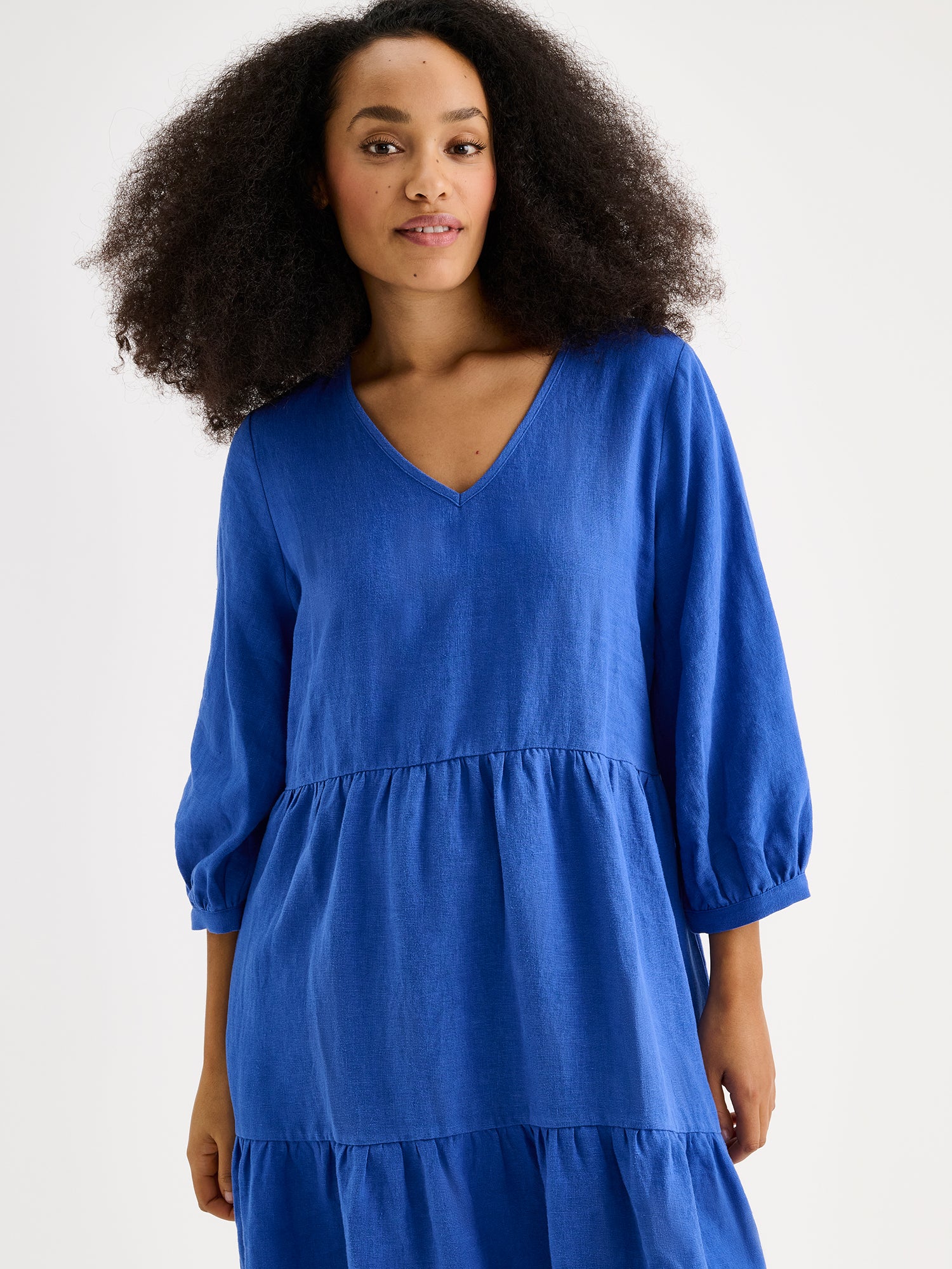 Nanson sininen midipituinen frillahelmainen Saralivia pellavamekko, jossa on kauniit 3/4 hihat, sivutaskut ja V-pääntie. Pellavamekon istuvuus on väljä ja materiaali on hengittävä. Lähikuvassa mallin päällä.