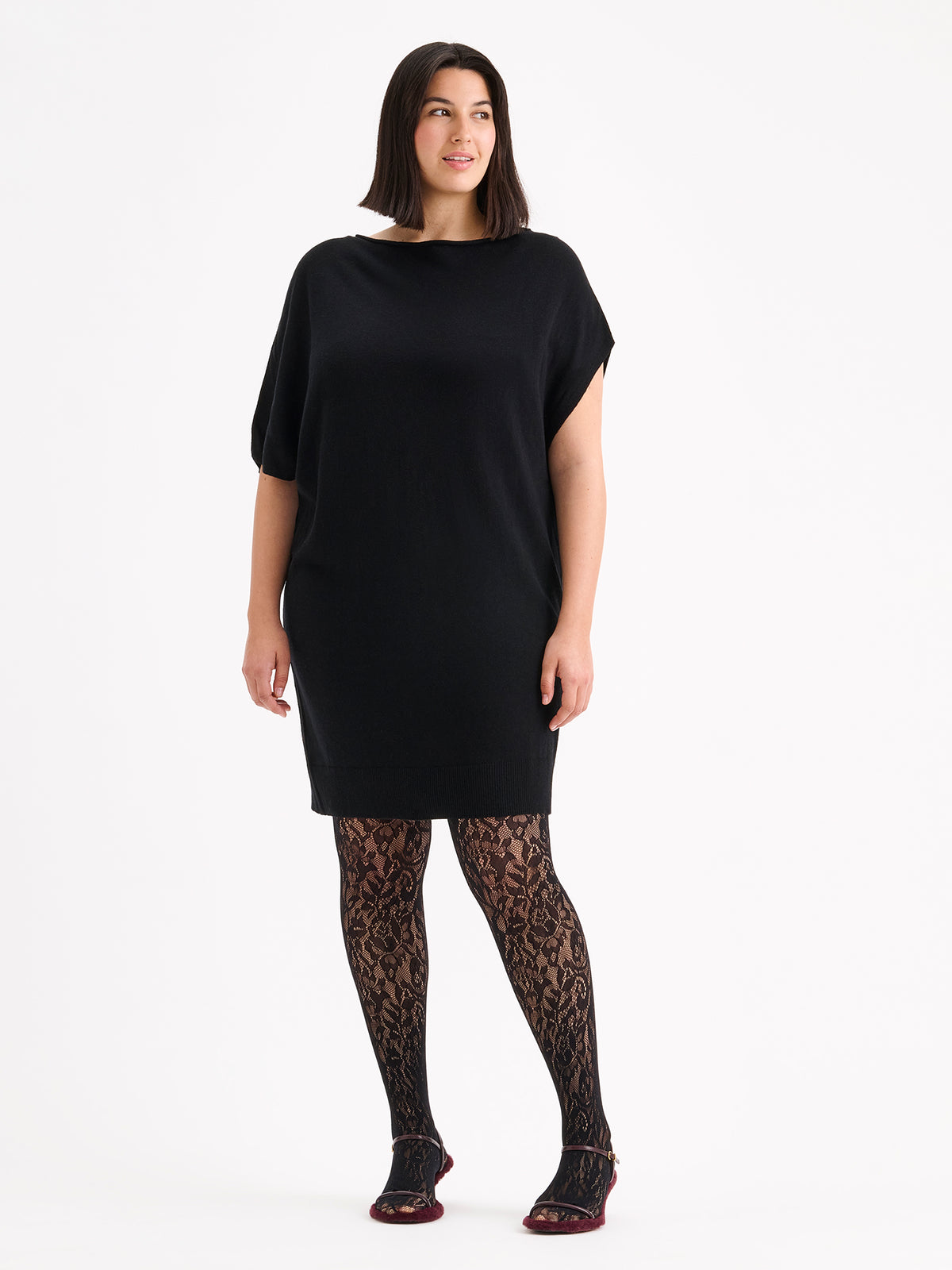Naisten Villis-neulemekossa on näyttävä epäsymmetrinen siluetti, joka luo modernin ja elegantin ilmeen. Kuvassa mallin päällä pitsisukkahousujen kanssa. XL - 178cm