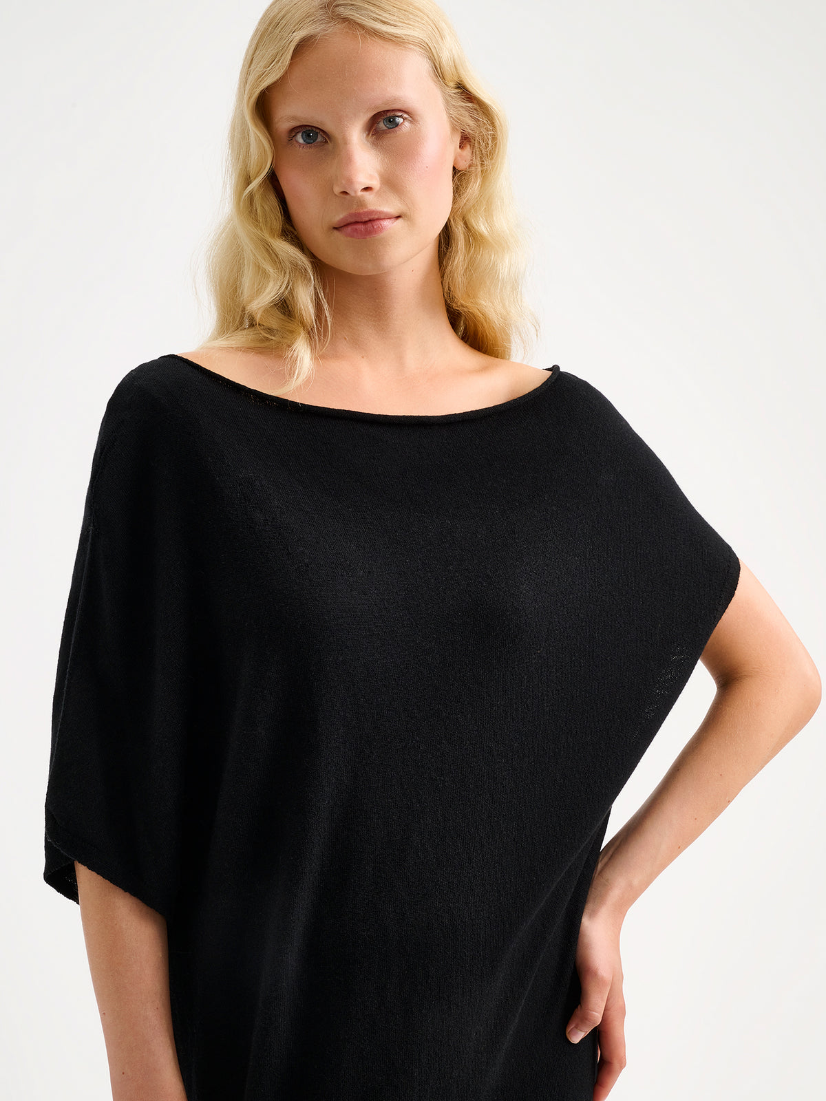 Naisten Villis-neulemekossa on näyttävä epäsymmetrinen siluetti, joka luo modernin ja elegantin ilmeen. Lähikuvassa mallin päällä. S - 174cm