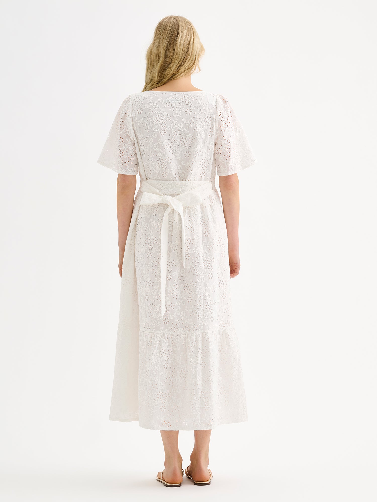Nanson naisten kaunis pitkä luonnonvalkoinen Odette-mekko pitsimäisestä Broderie anglaise -tyyppisestä puuvillakankaasta mallin päällä takaa kuvattuna.