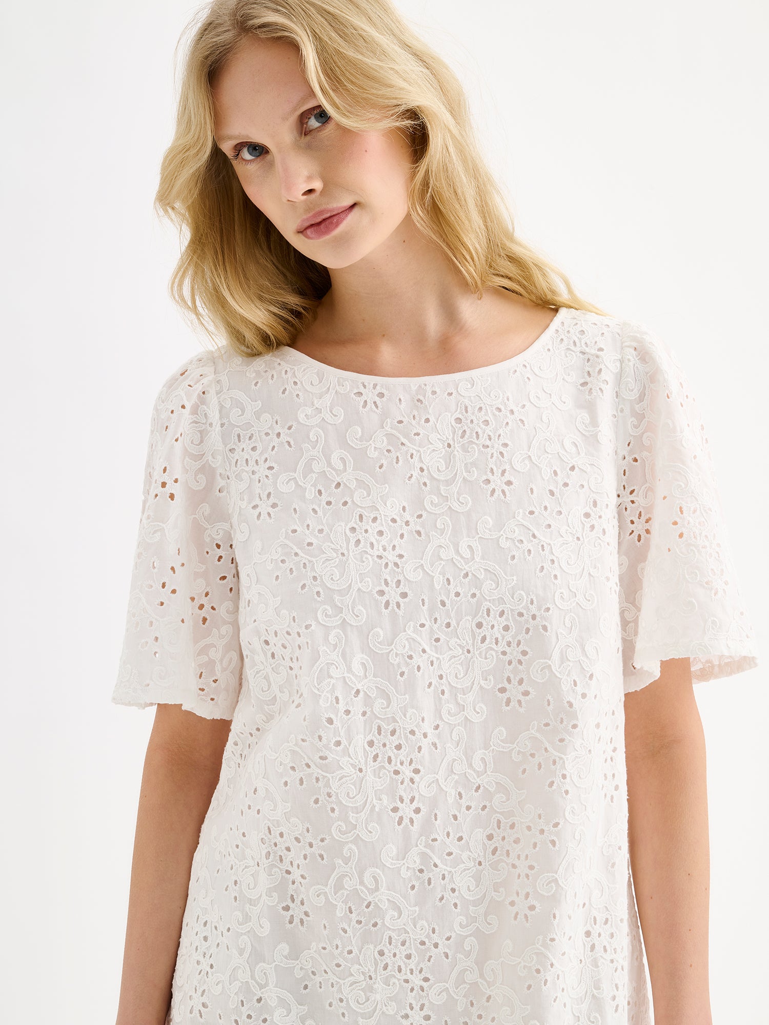 Nanson pitsikirjailtu luonnonvalkoinen Odette mekko mallin päällä lähikuvassa.