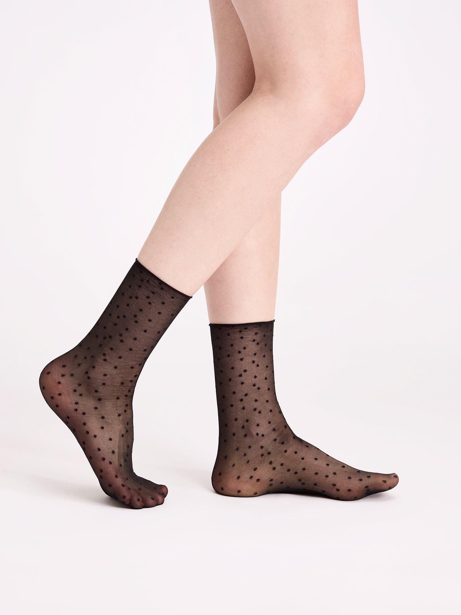 Voguen tyylikkäät 20 denierin nilkkasukat, joissa trendikäs pilkkukuviointi. Kuvassa mallin päällä.