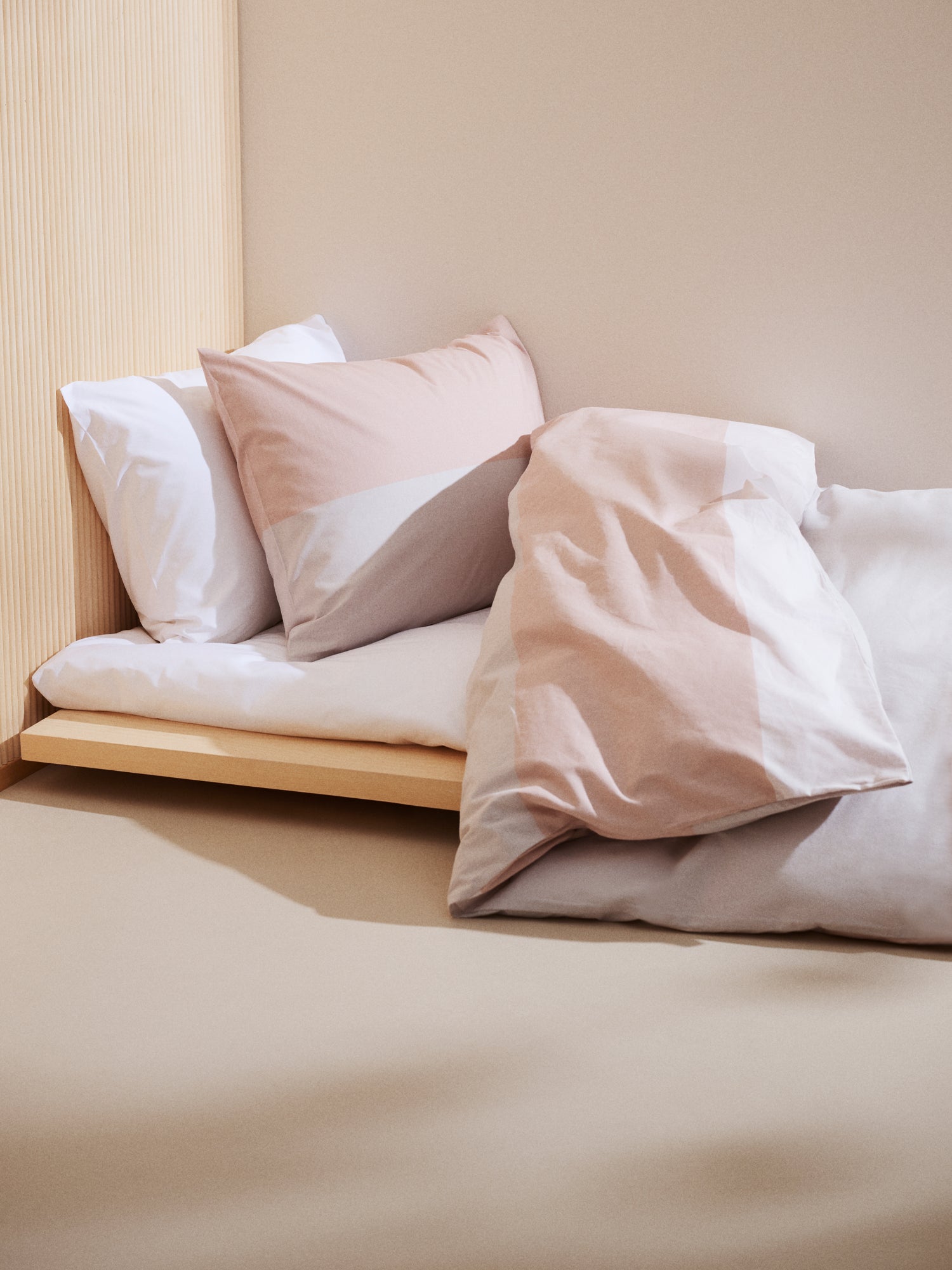 Nanson beige Trio-pussilakanasetissä on kaunis leveä raitakuosi, sängyssä