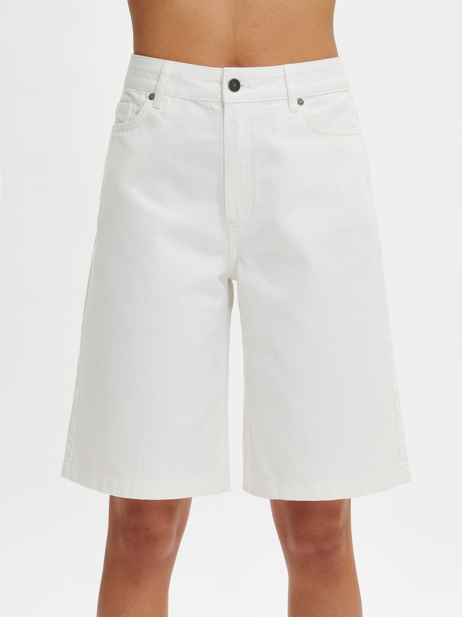 Nanson naisten mukavat rennosti istuvat luonnonvalkoiset Levee-shortsit farkkumateriaalista vyötärökaitaleella, jossa edessä vetoketju ja polviin asti ulottuvat levenevät lahkeet  mallin yllä lähikuvassa edestä.